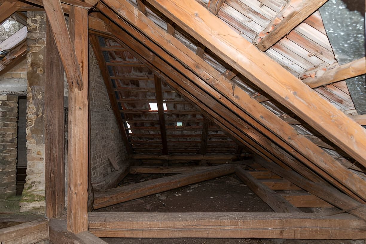 Wooden attic framing with brick walls.
