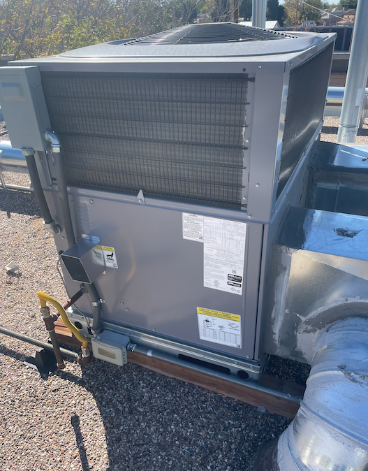 A large air conditioner is sitting on top of a roof.