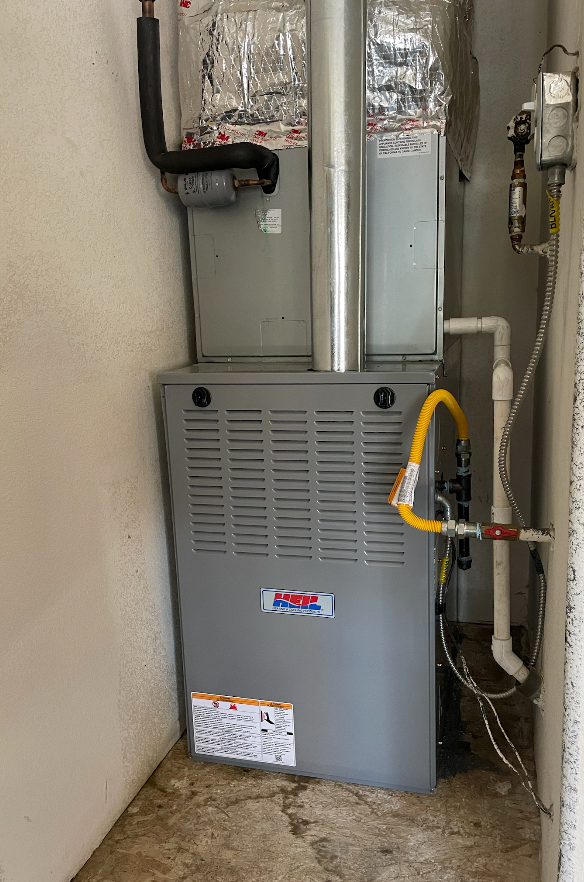 A gas furnace is sitting in a room next to a wall.