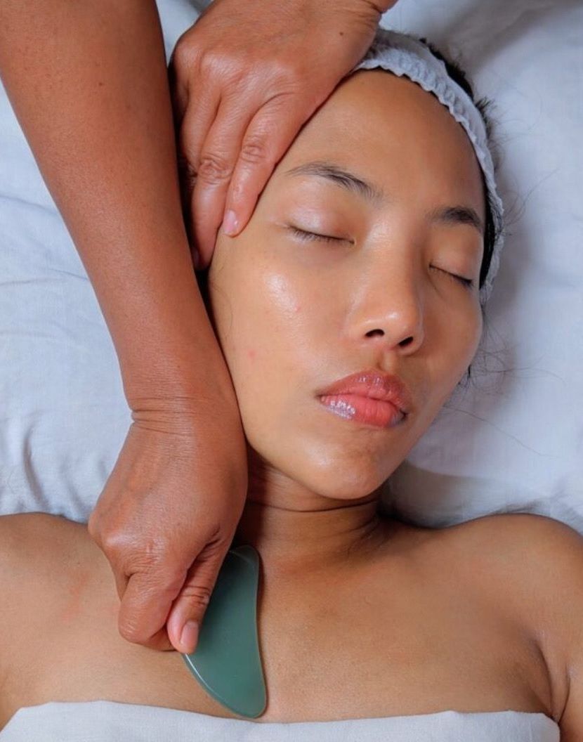 A woman wearing pink gloves is holding a syringe.