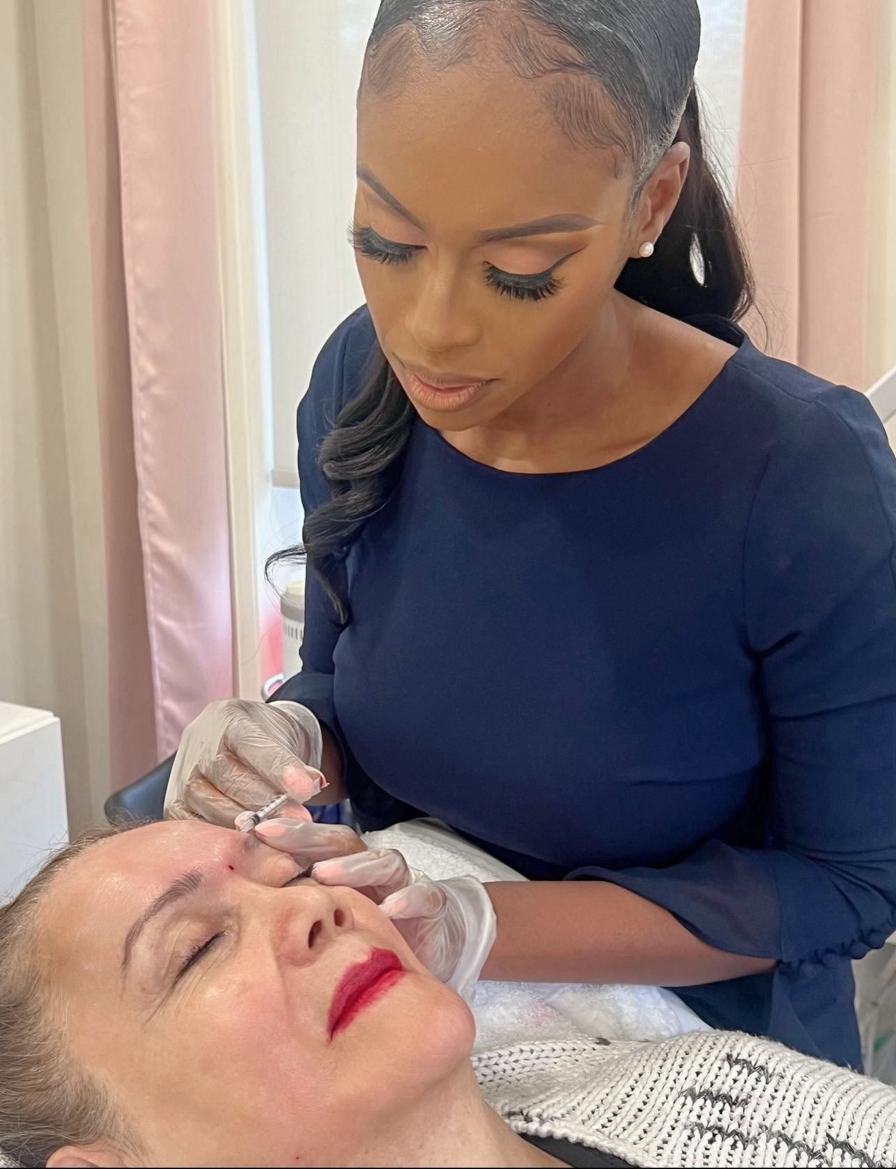 A woman is getting a botox injection in her forehead.