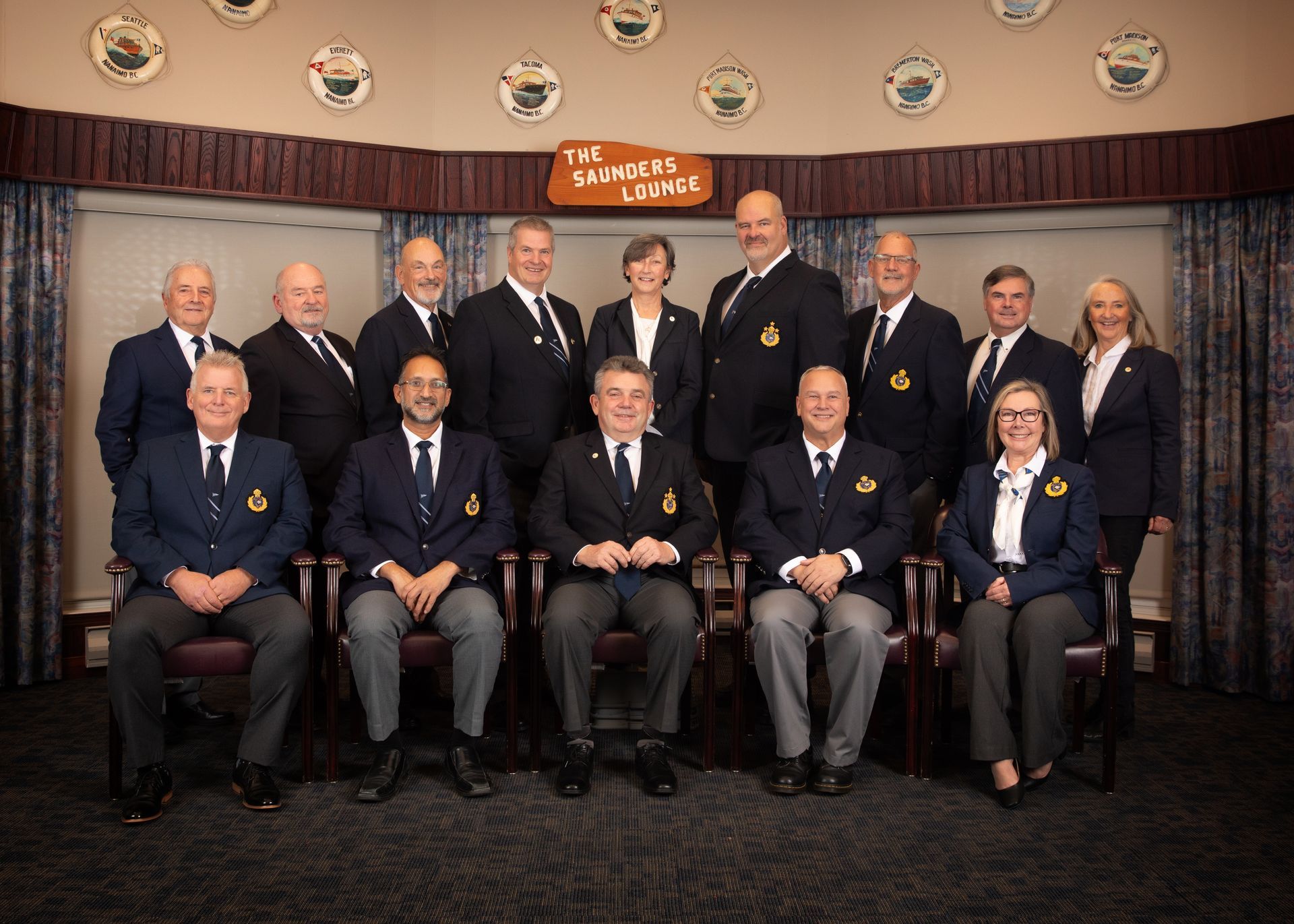 A group of people in suits and ties are posing for a picture.