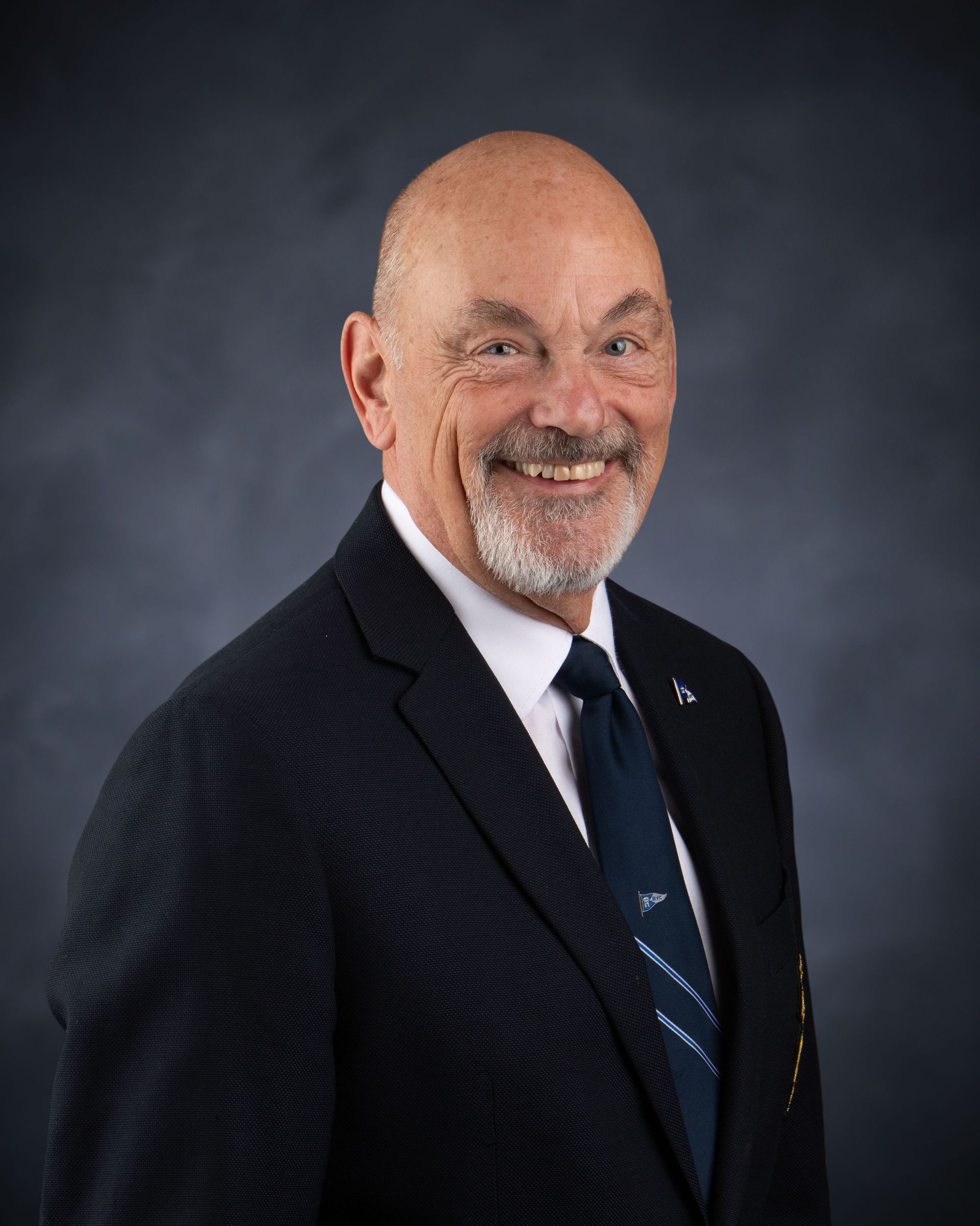 A man in a suit and tie is smiling for the camera.