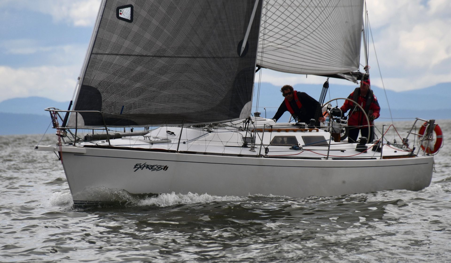A sailboat with a black sail is in the water