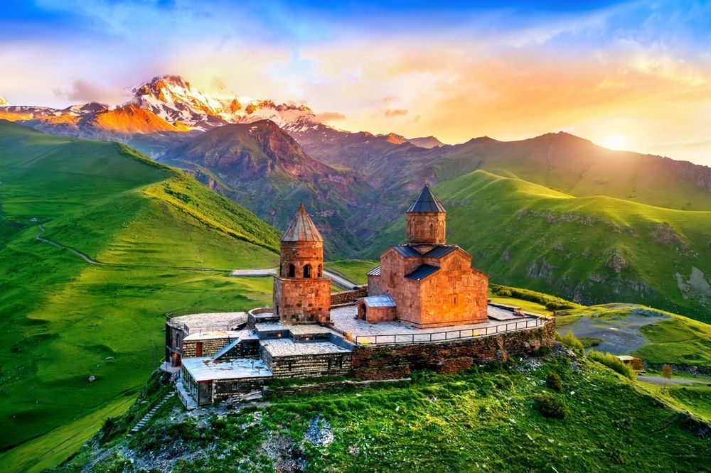 Gergeti Trinity Church in Georgia mountains at sunrise.