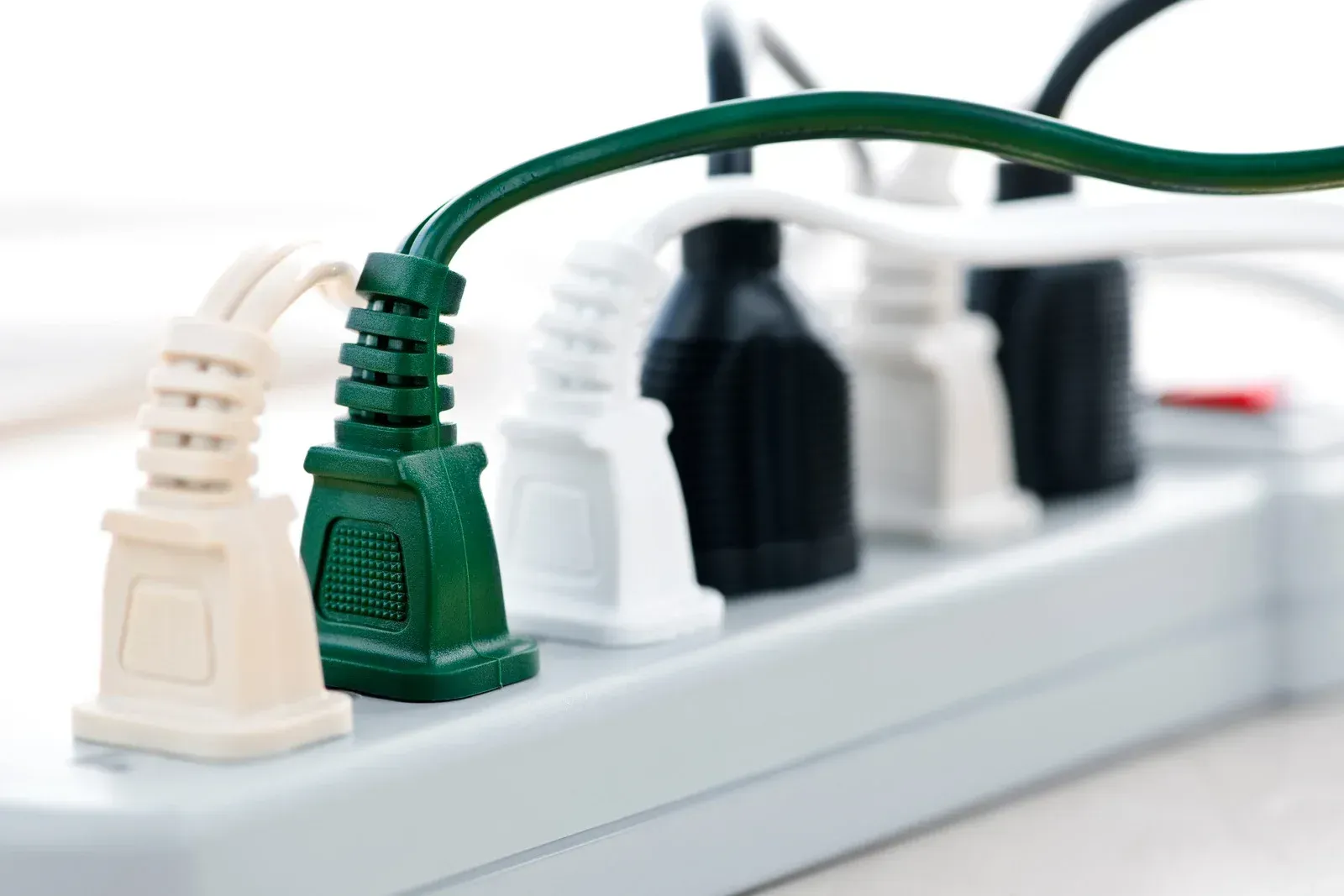 A bunch of plugs are plugged into a power strip.