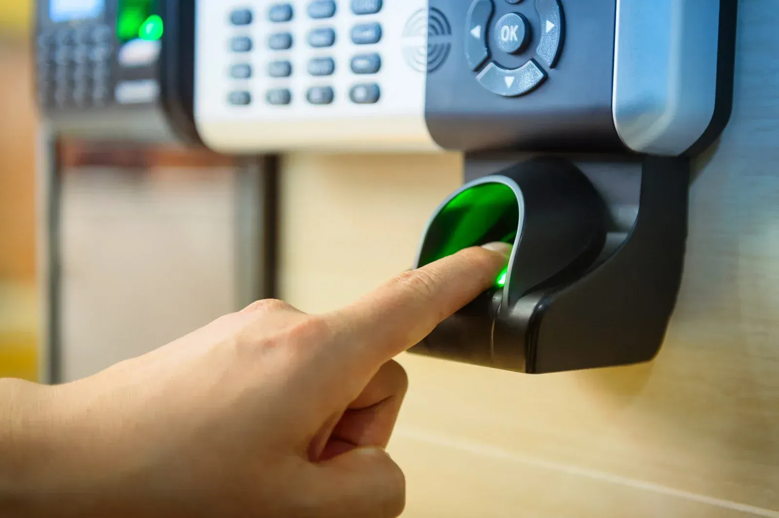 A person is pressing their finger on a fingerprint scanner.