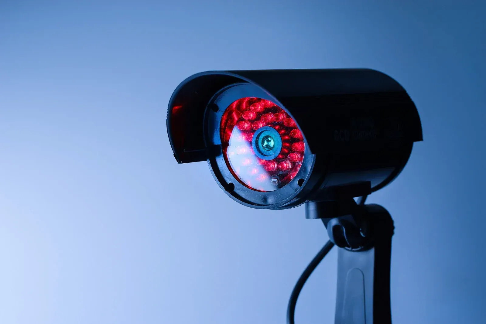 A close up of a security camera with a red light on it.