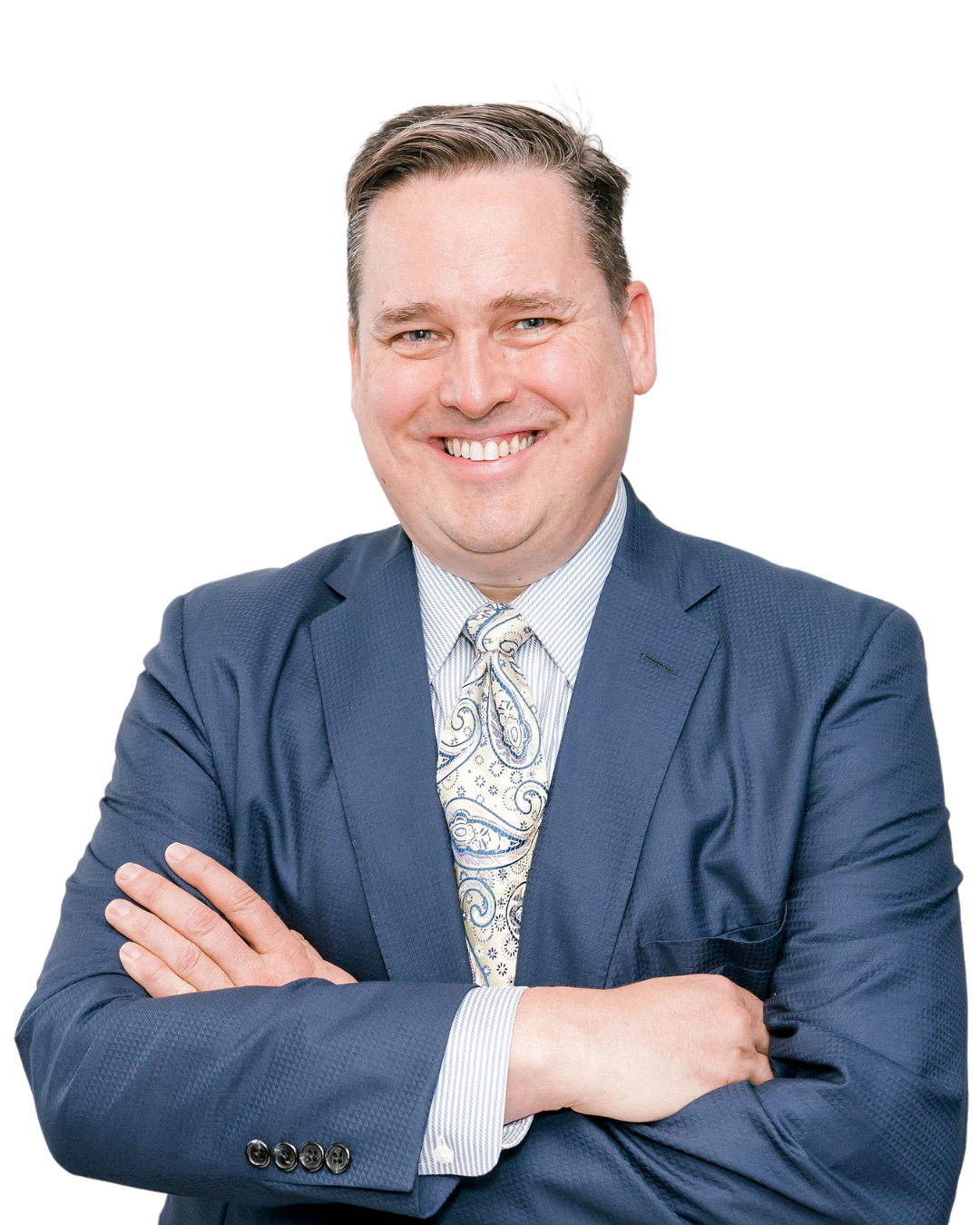 A man in a suit and tie is smiling with his arms crossed.