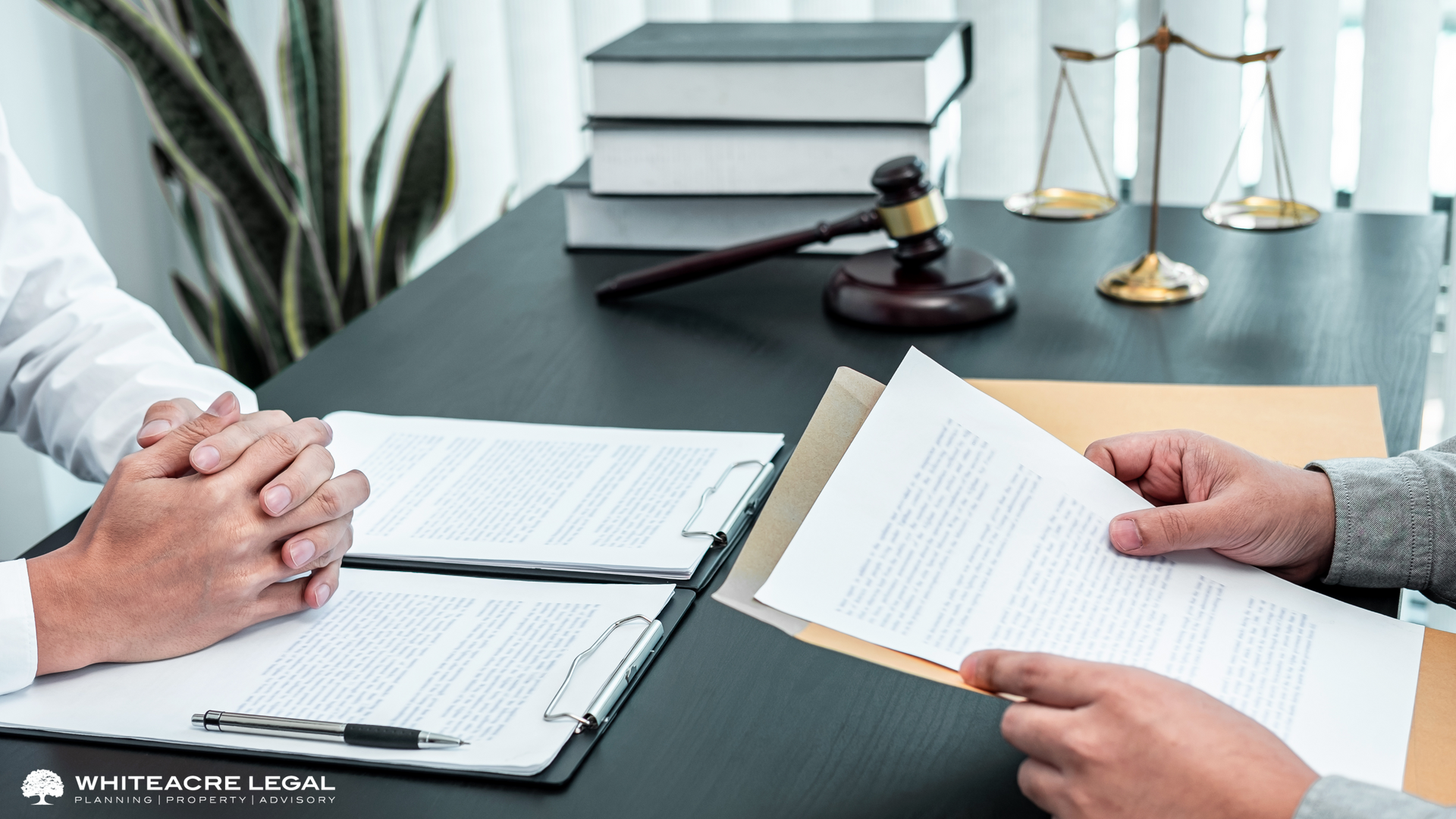 Two people are sitting at a table with papers and a judge 's gavel.