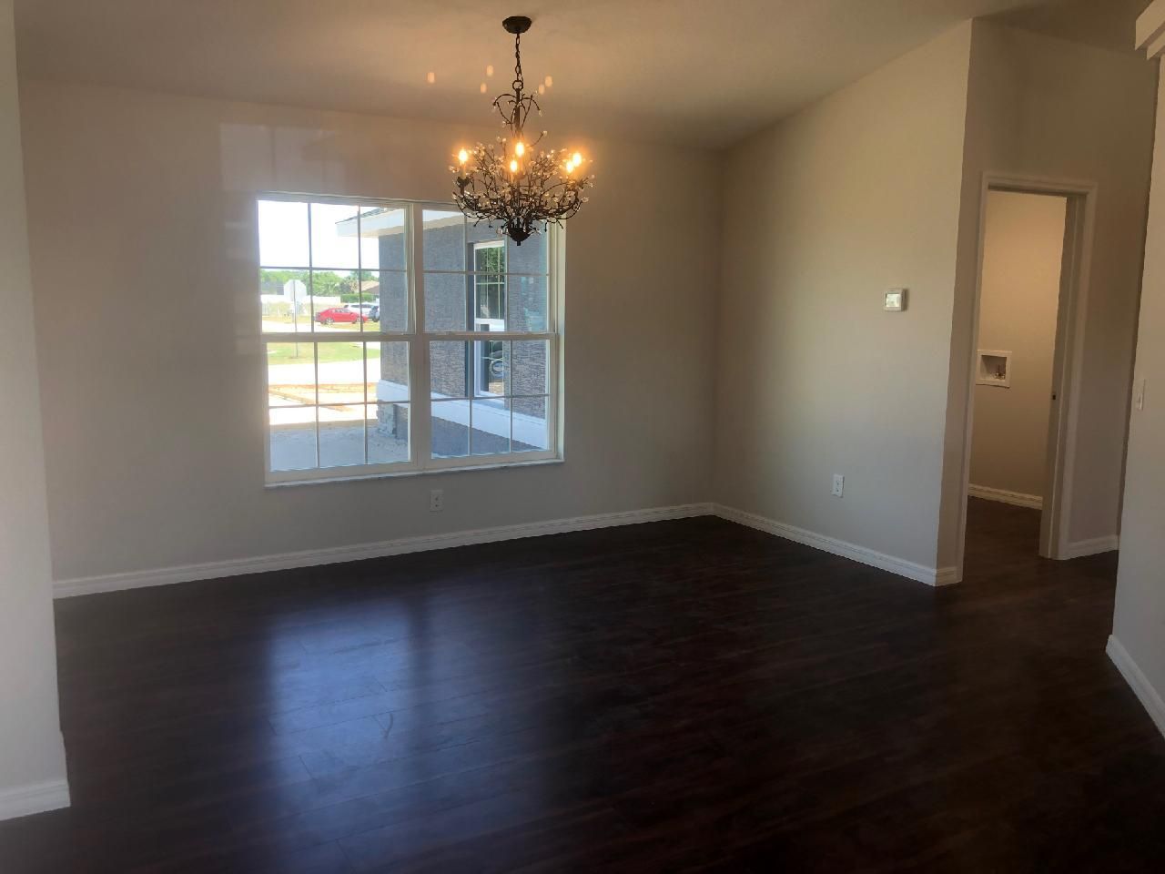 An empty room with a chandelier hanging from the ceiling