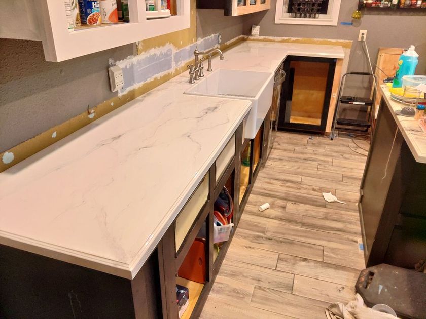 A kitchen with a white counter top and a sink