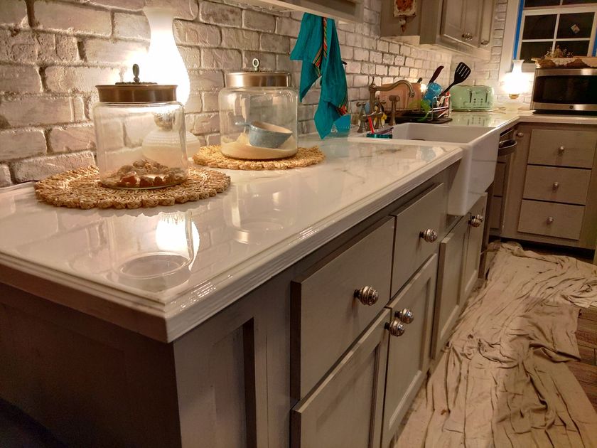 A kitchen with white cabinets and a white sink