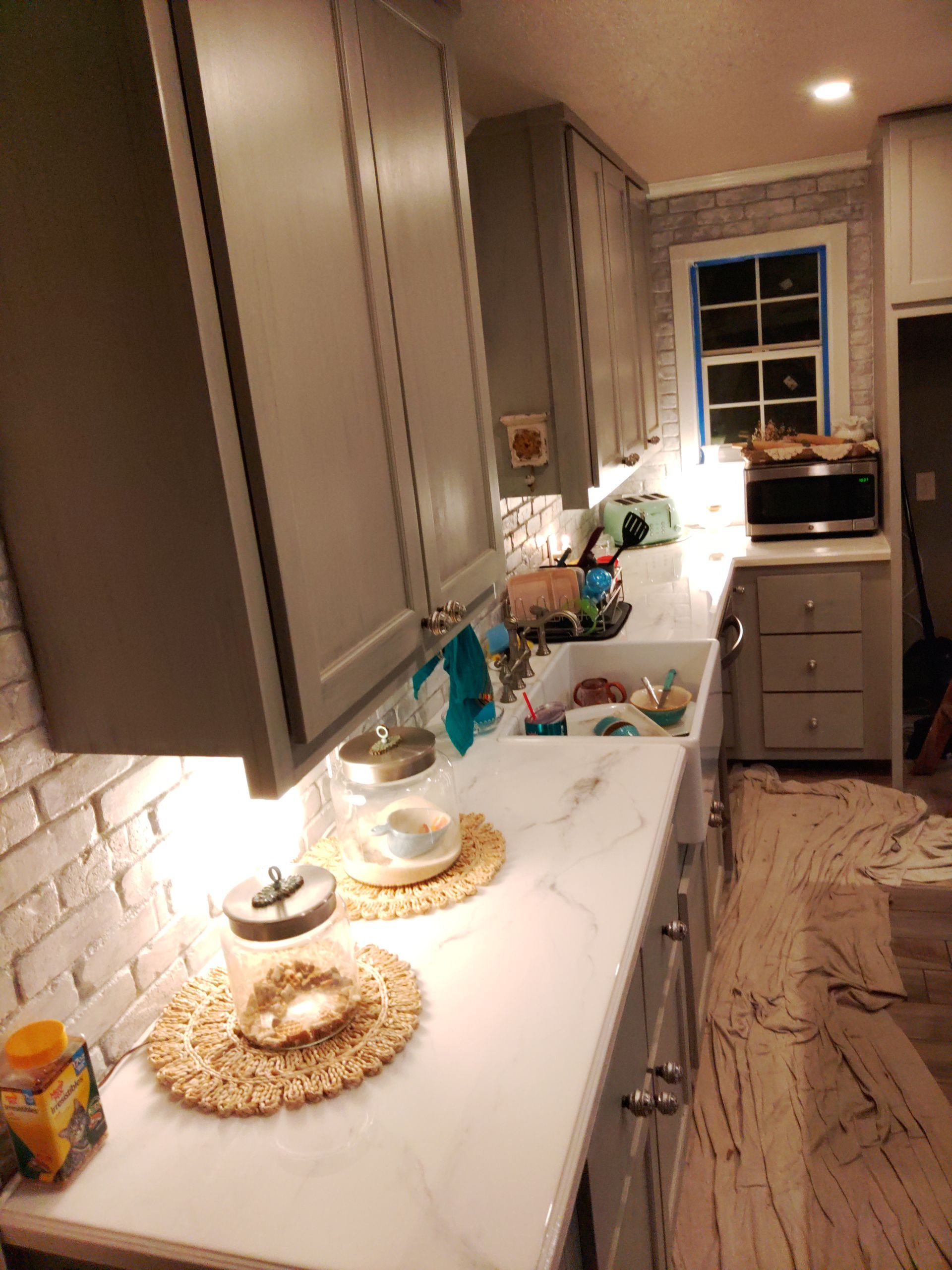 A kitchen with white cabinets and marble counter tops