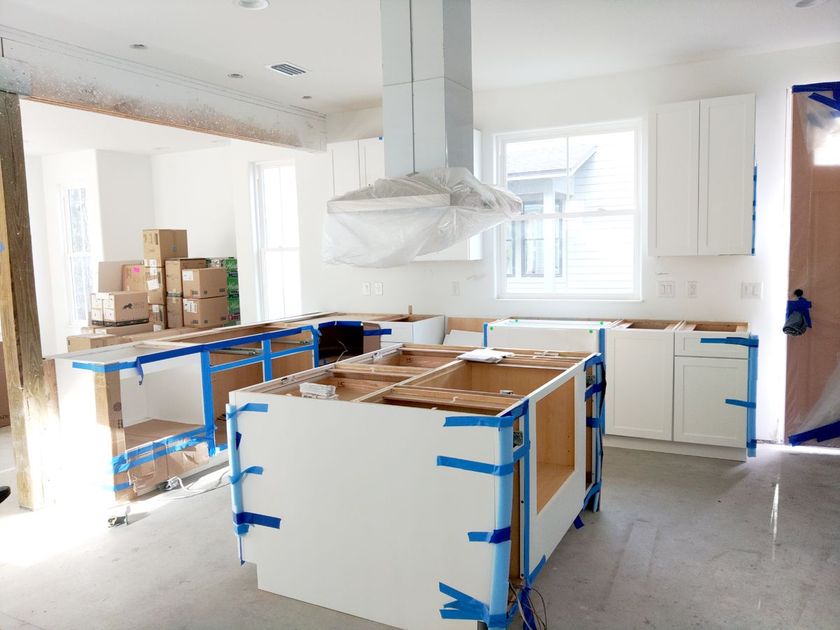 A kitchen that is being remodeled with white cabinets.