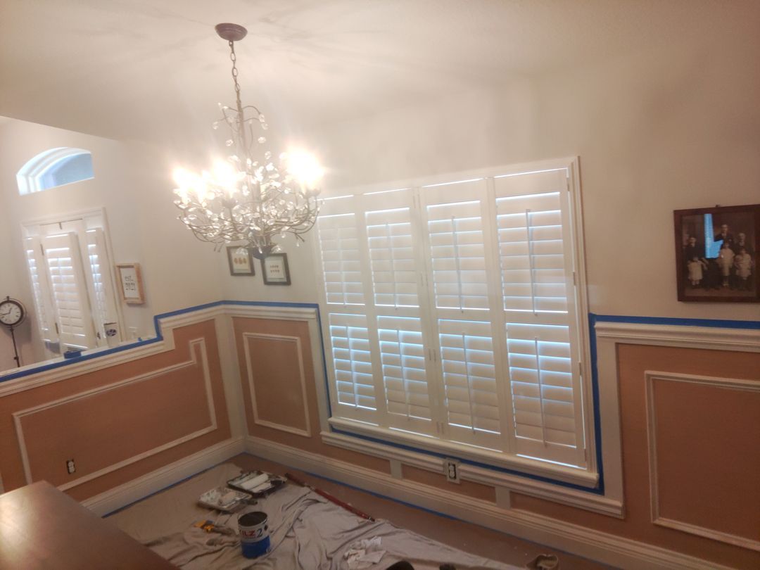 A dining room with shutters and a chandelier