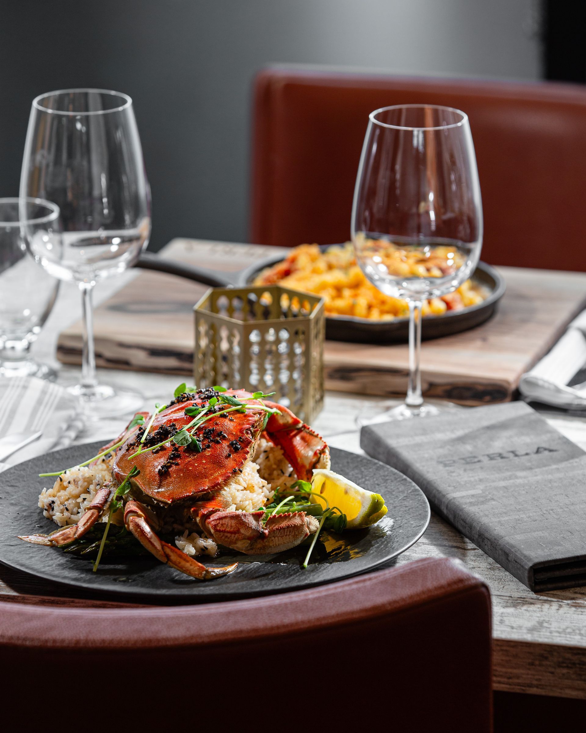 A plate of food and wine glasses on a table.
