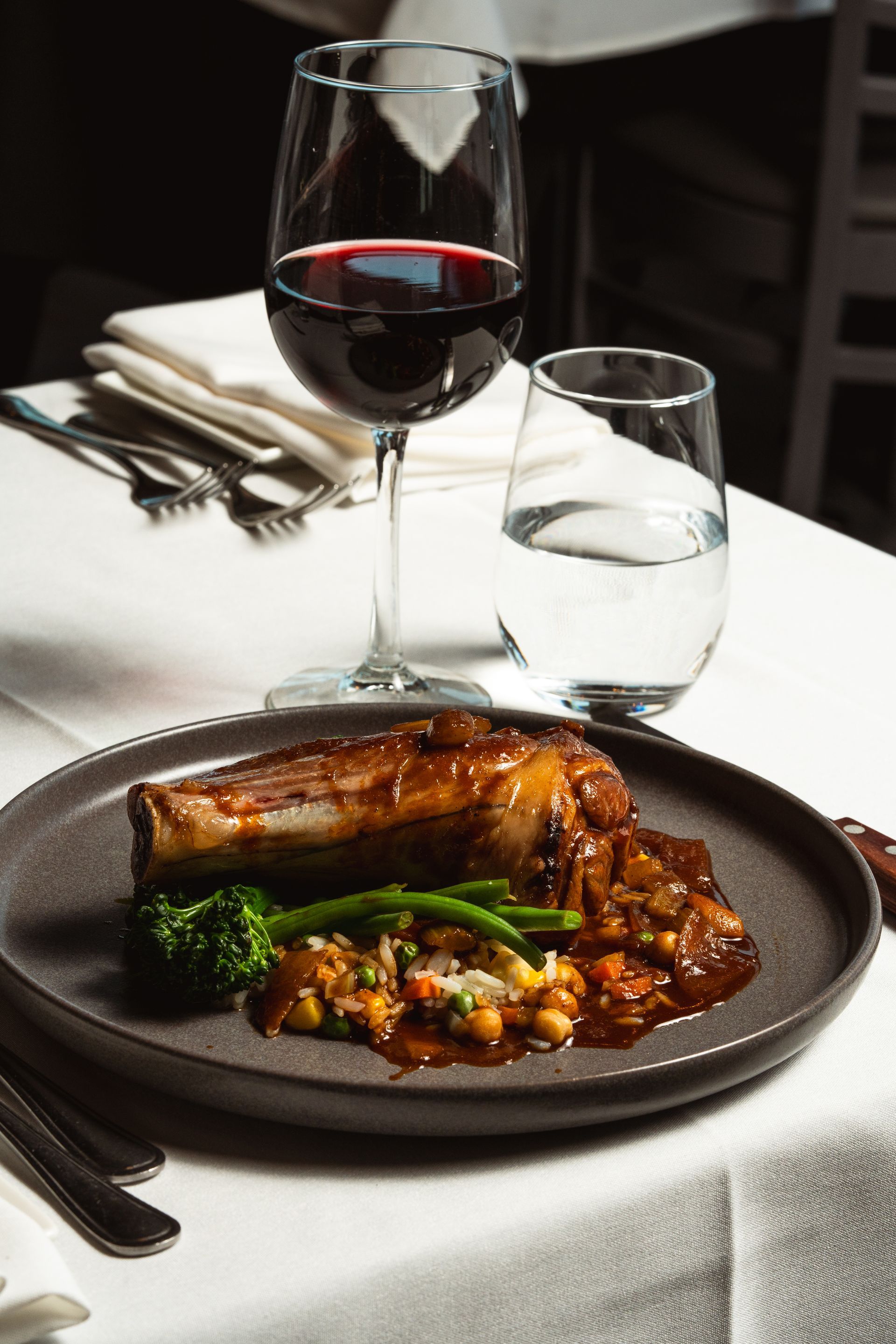 A plate of food and a glass of wine on a table.
