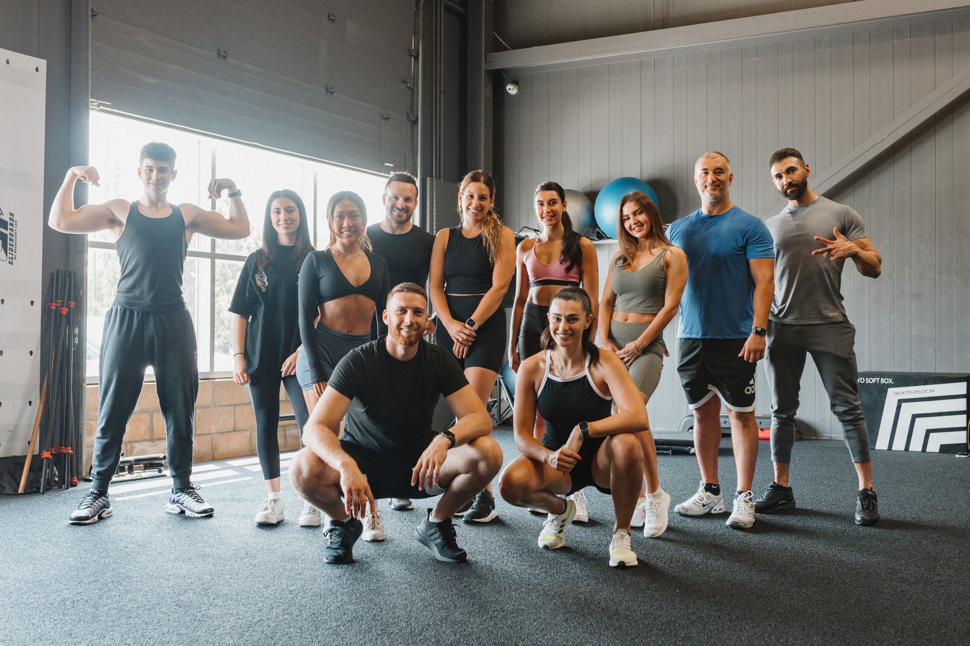 A group of people are posing for a picture in a gym.