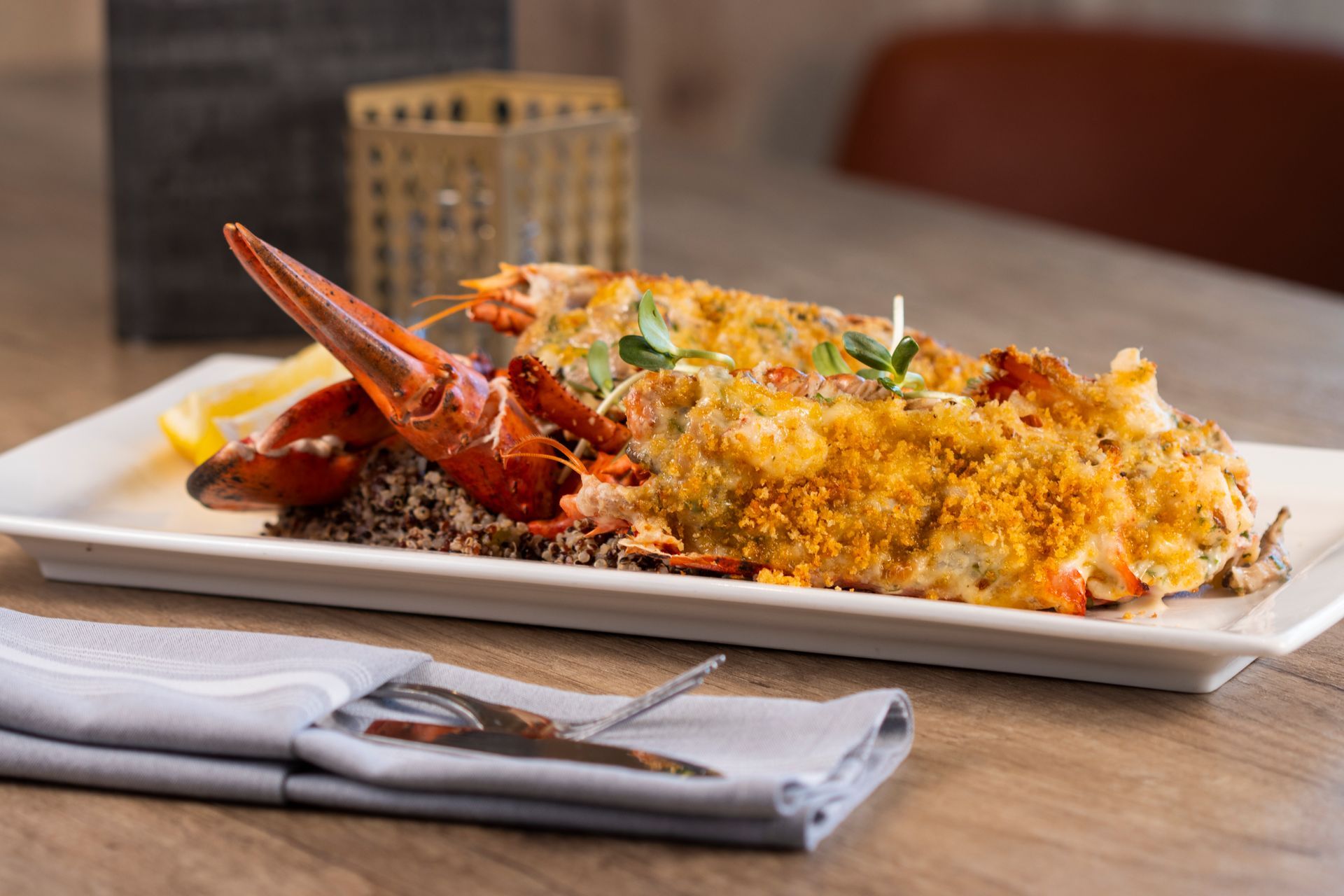 A white plate topped with a lobster and rice on a table.