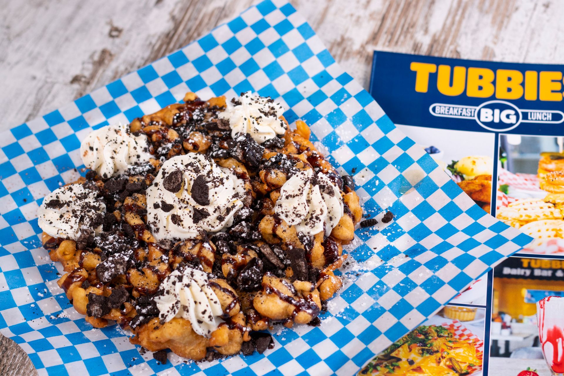 A blue and white checkered paper with a tubbie sign in the background