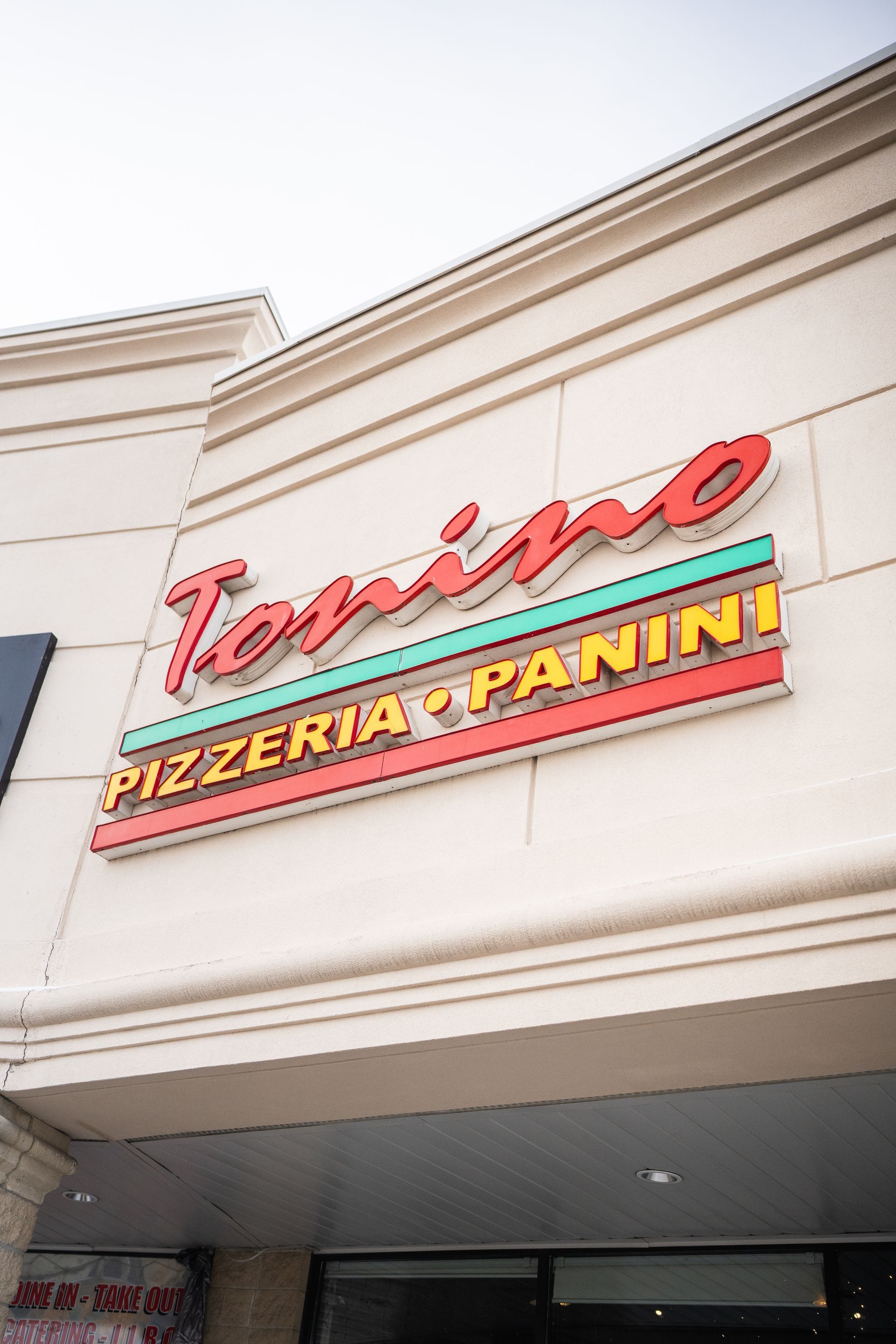 A close up of a pizzeria sign on a building.