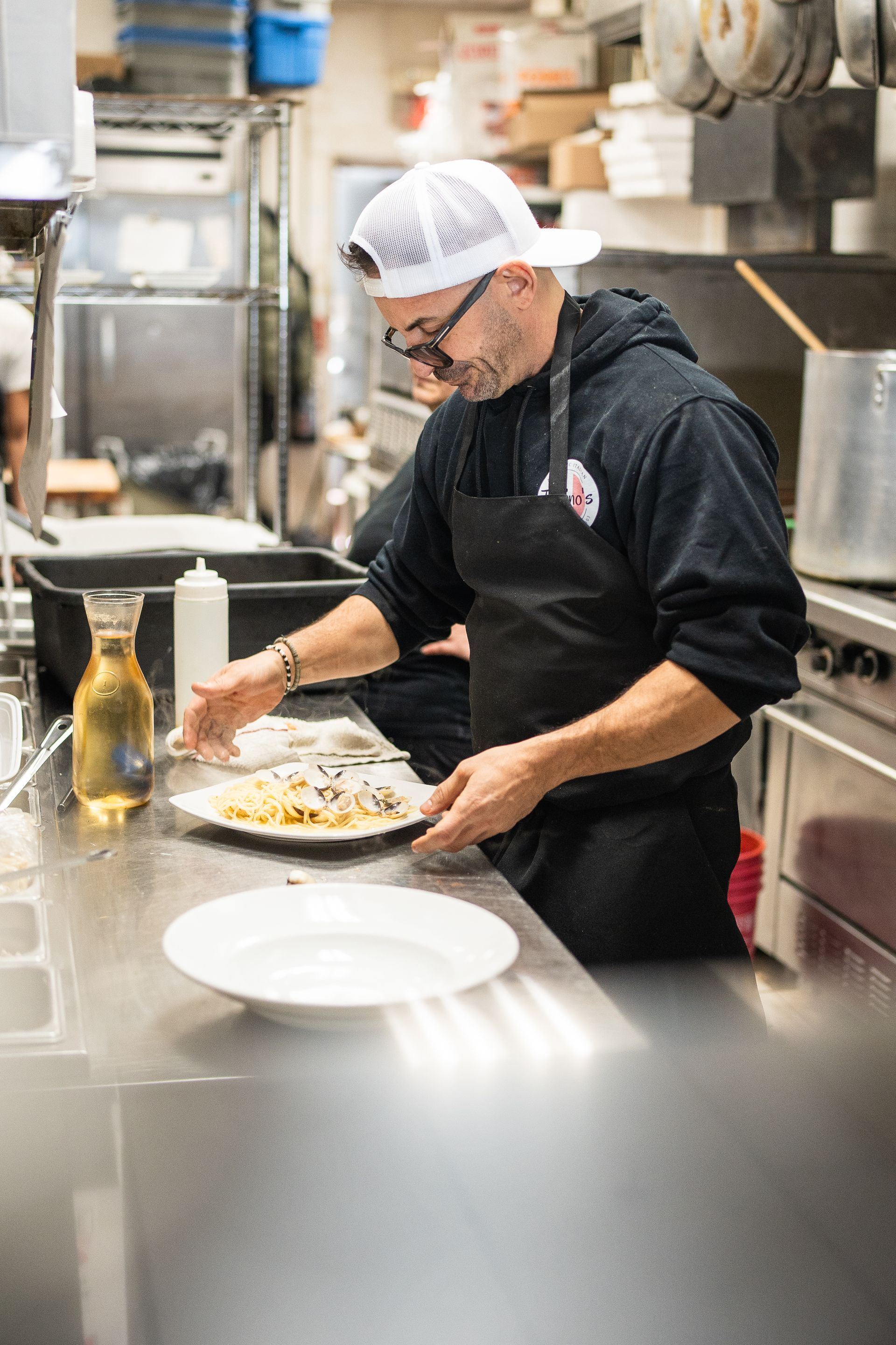 A man in an apron is preparing food in a kitchen.