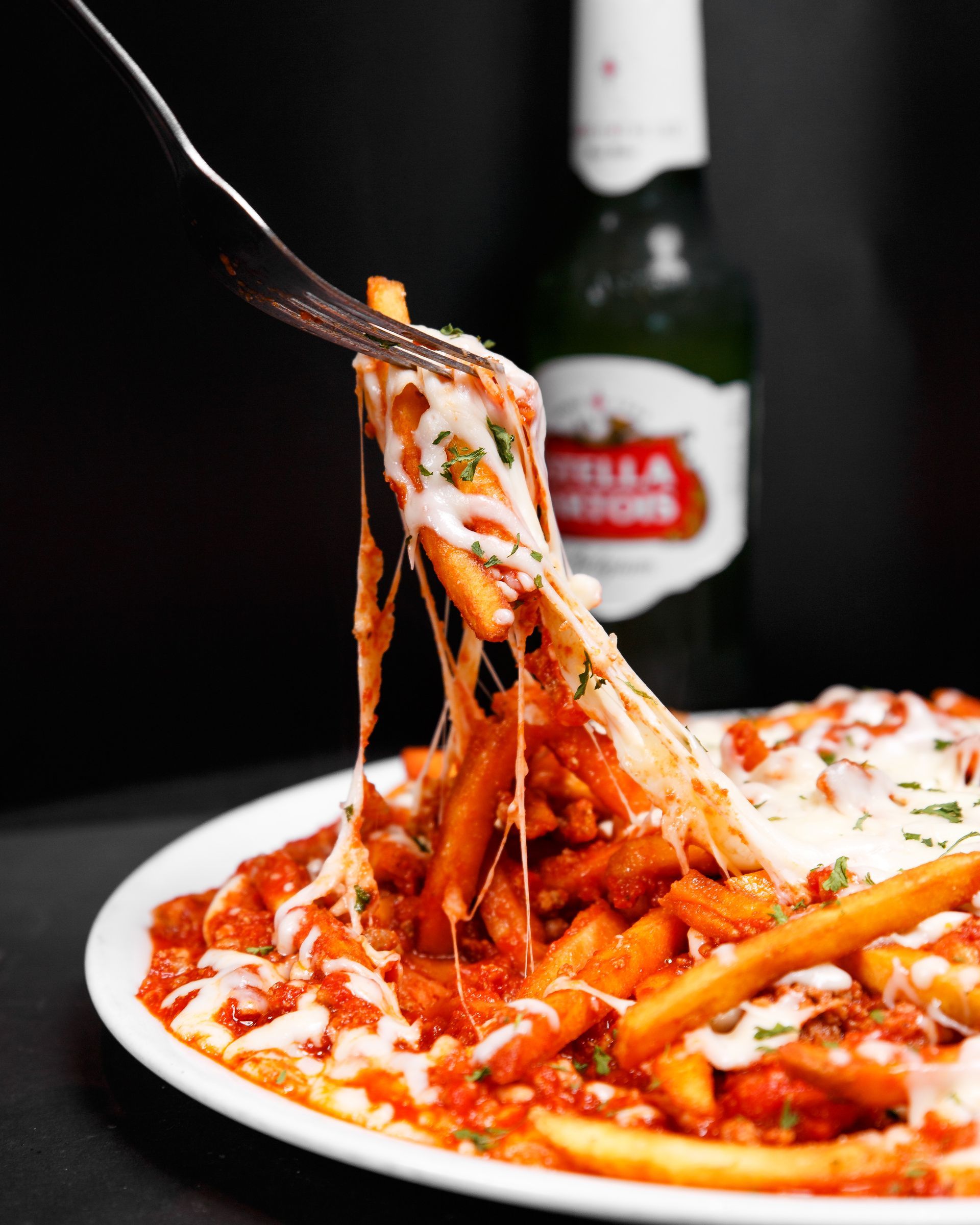 A plate of food with a bottle of stella artois in the background