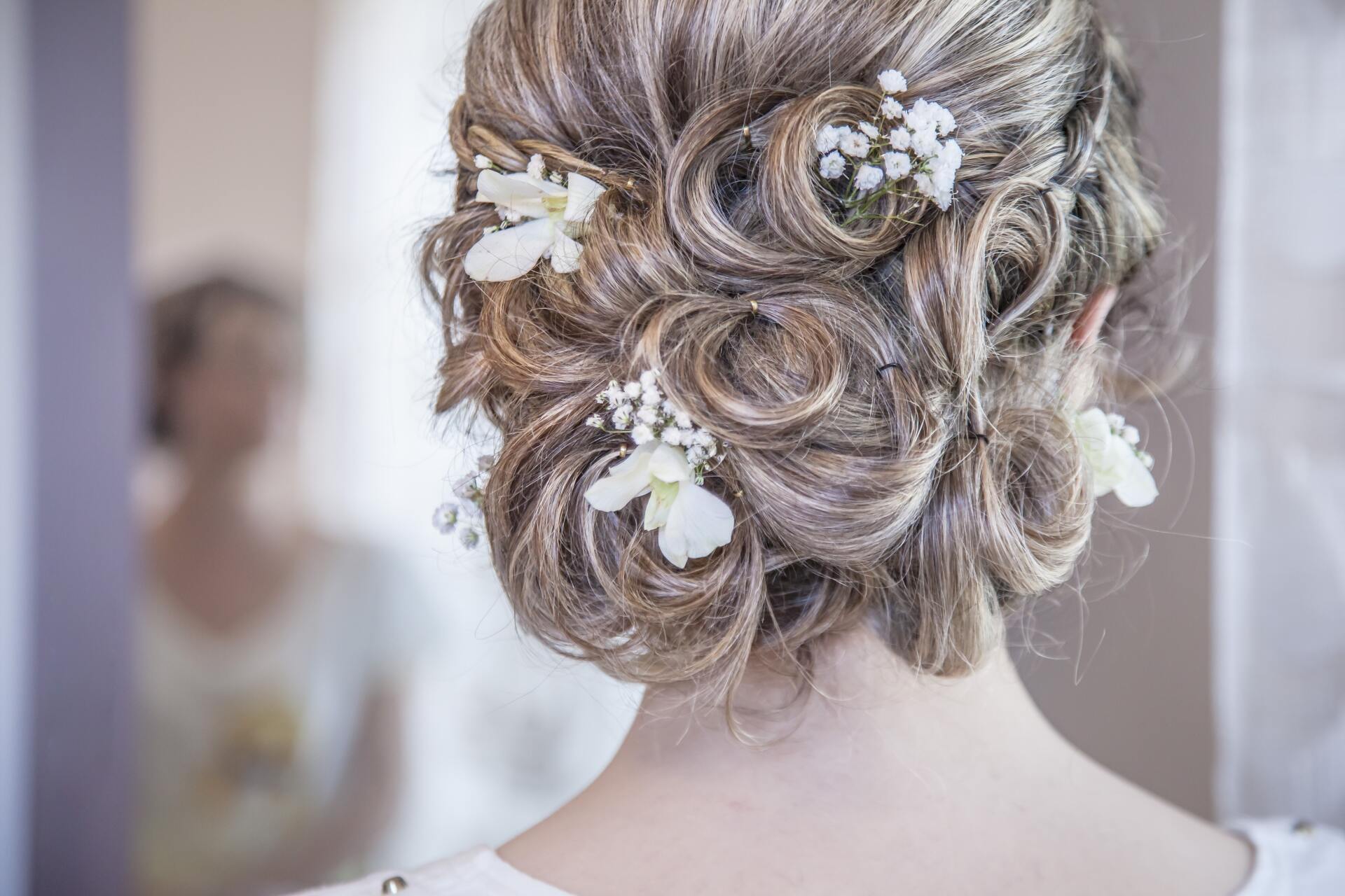 The back of a woman 's head with flowers in her hair.