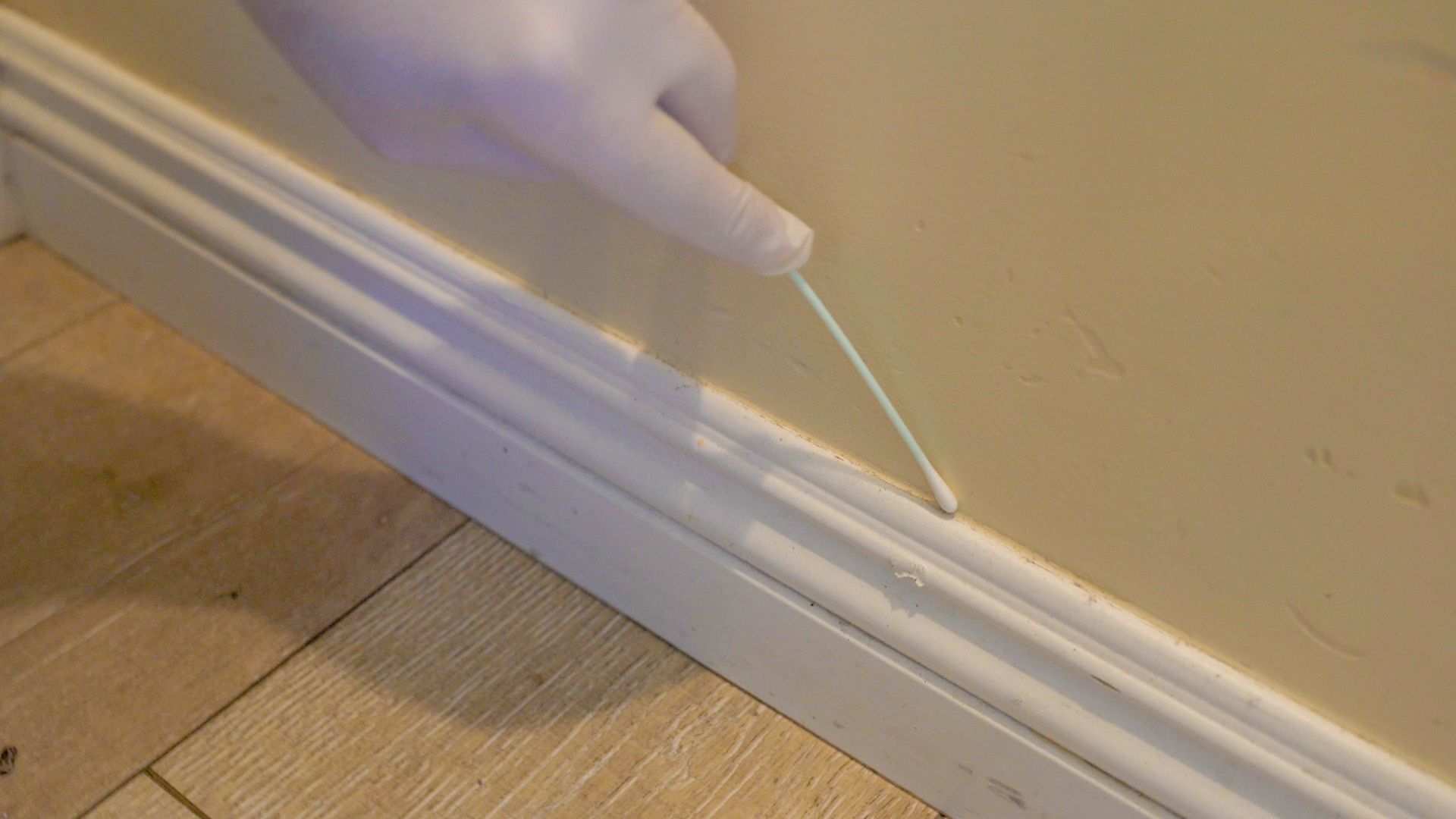 A person is cleaning a wall with a cotton swab