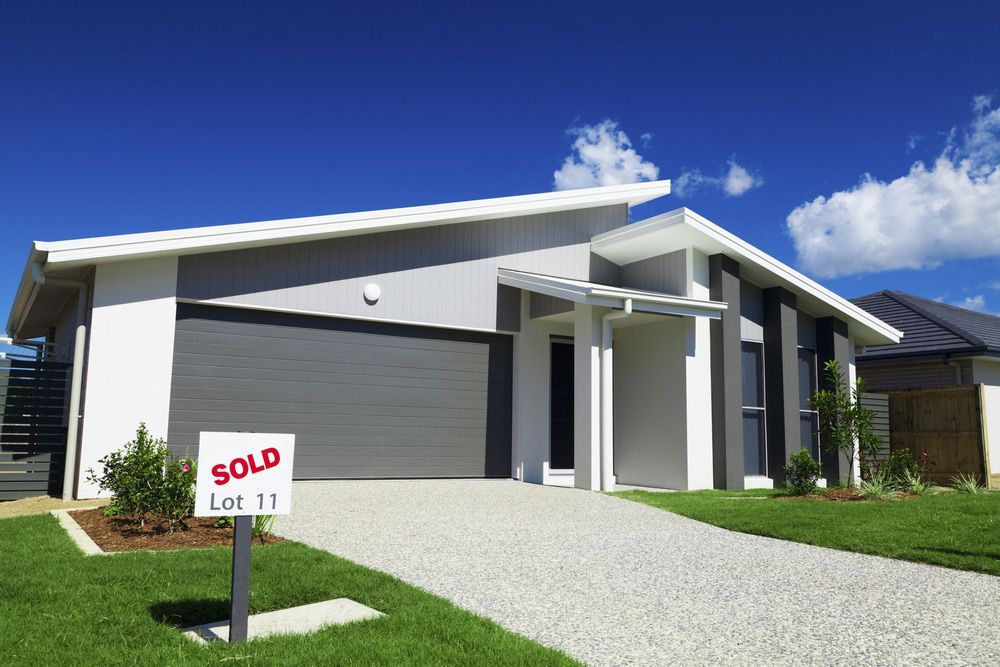 A House With A Sold Sign In Front Of It — Glenn Merrick Constructions In Bowen, QLD