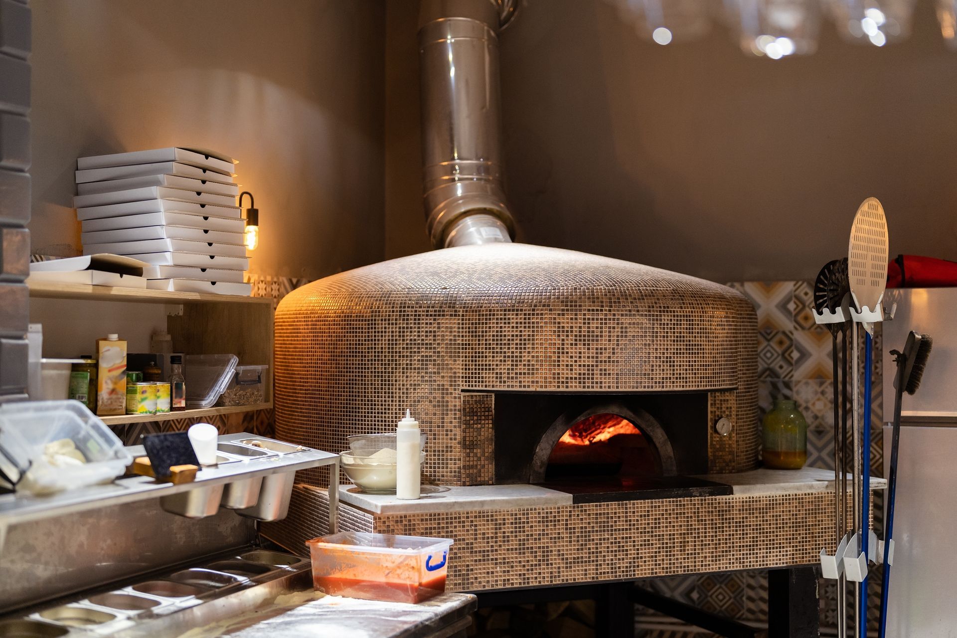 A pizza oven is sitting in a kitchen next to a counter.