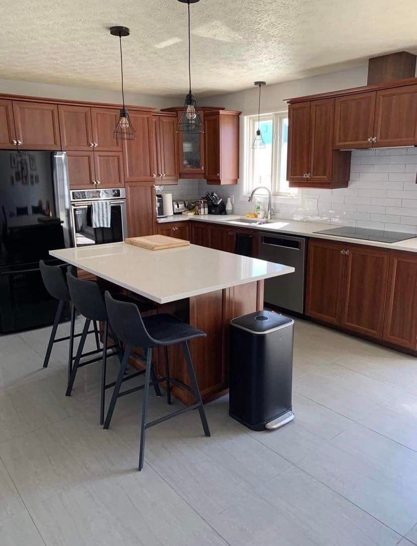 Une cuisine avec une table et des chaises dedans.