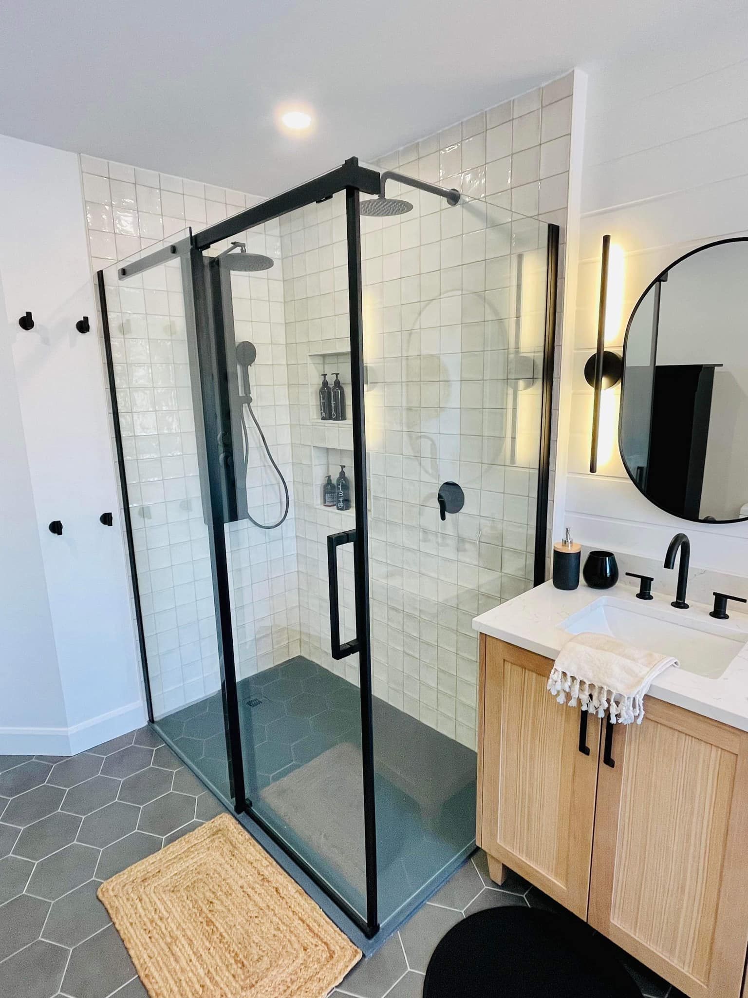 Une salle de bain avec douche à l'italienne, lavabo et miroir.
