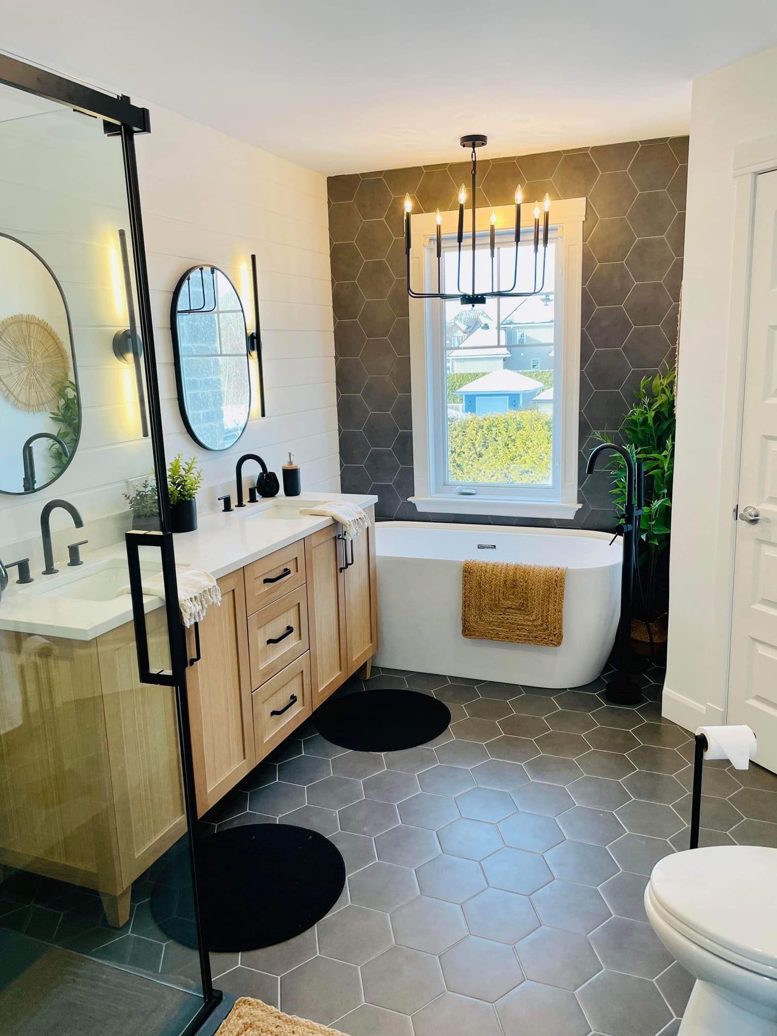 Une salle de bain avec baignoire, lavabo, WC et miroir.