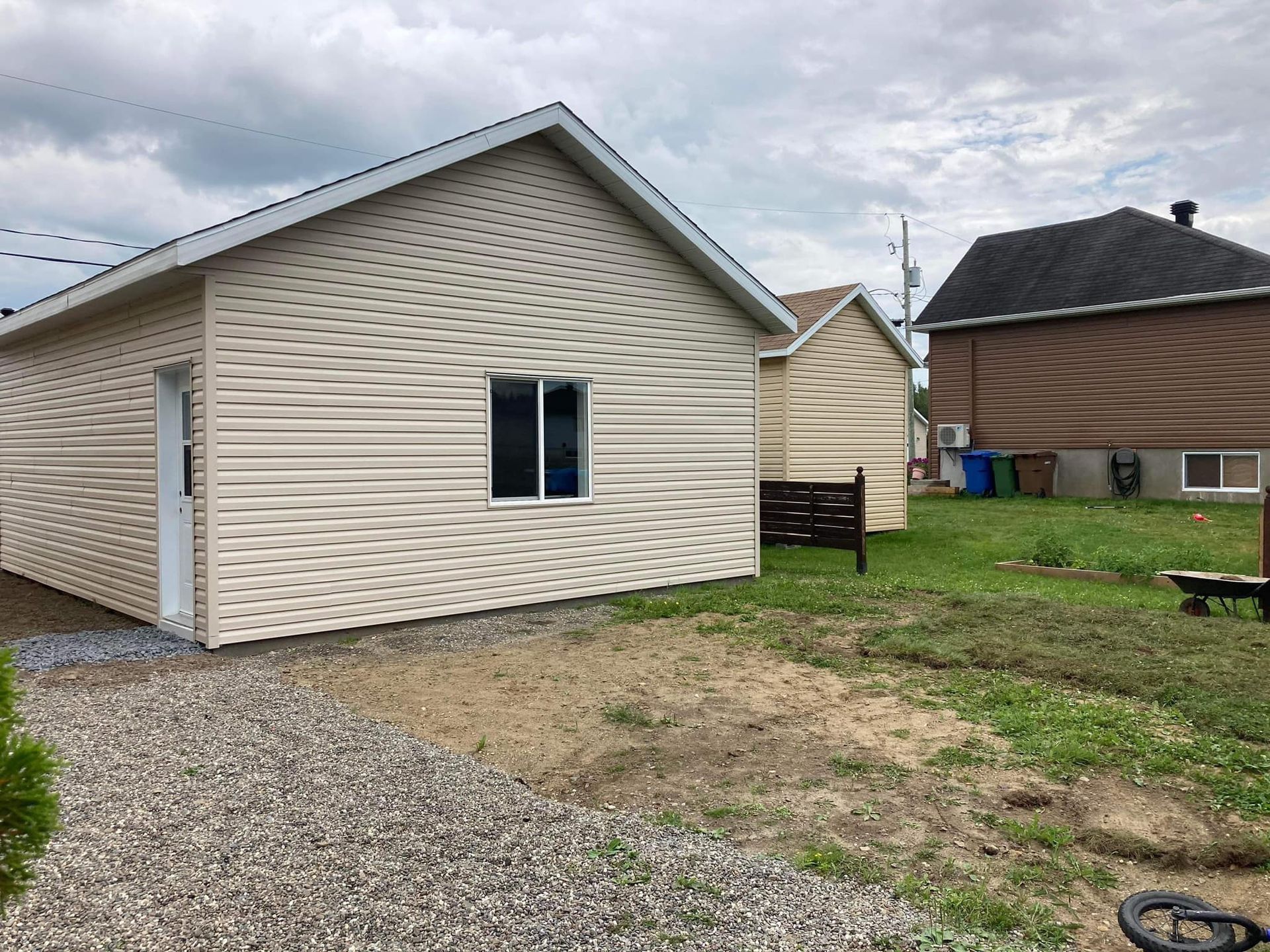 Une petite maison est située au milieu d'un champ herbeux.