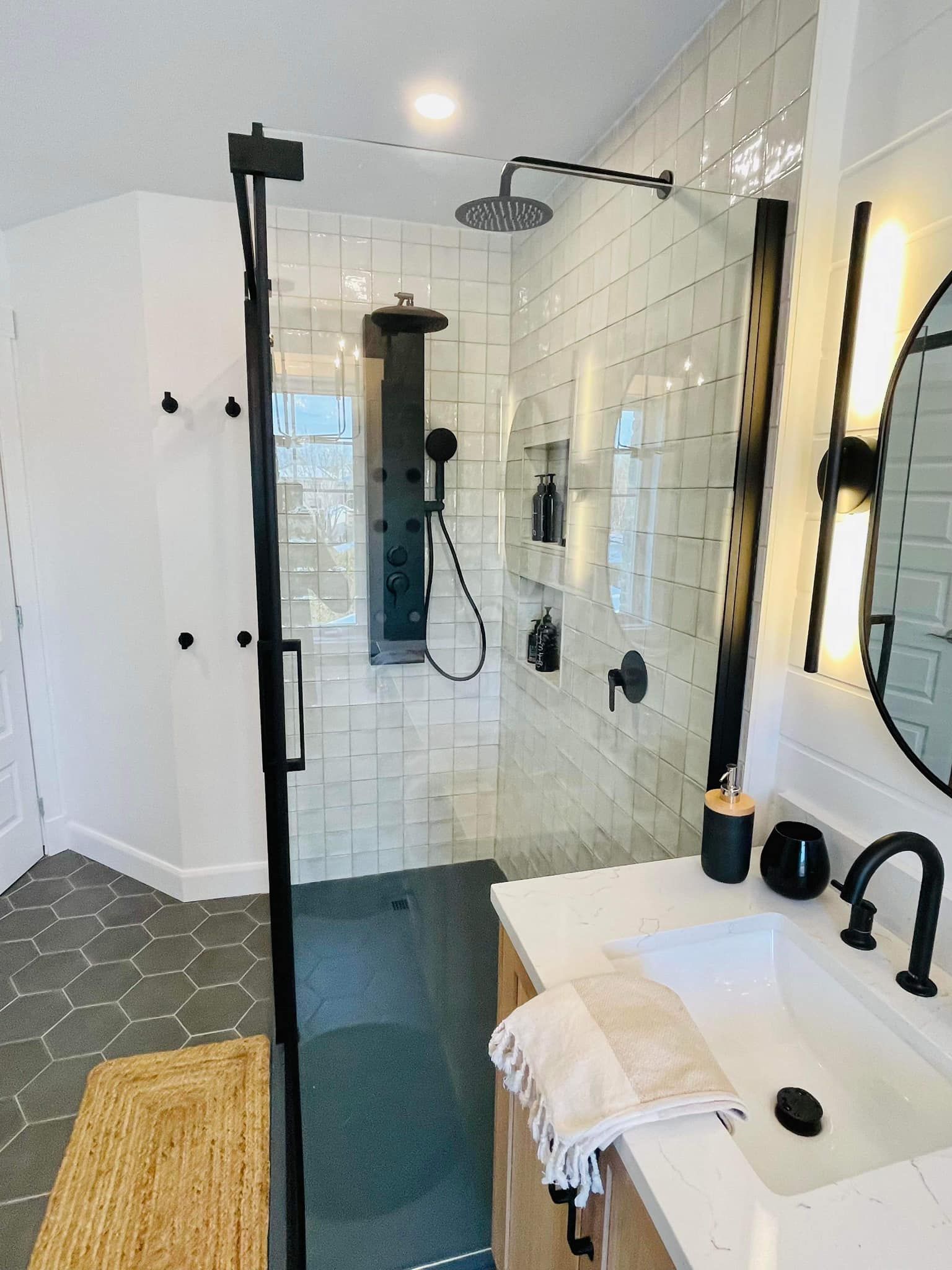 Une salle de bain avec douche à l'italienne, lavabo et miroir.