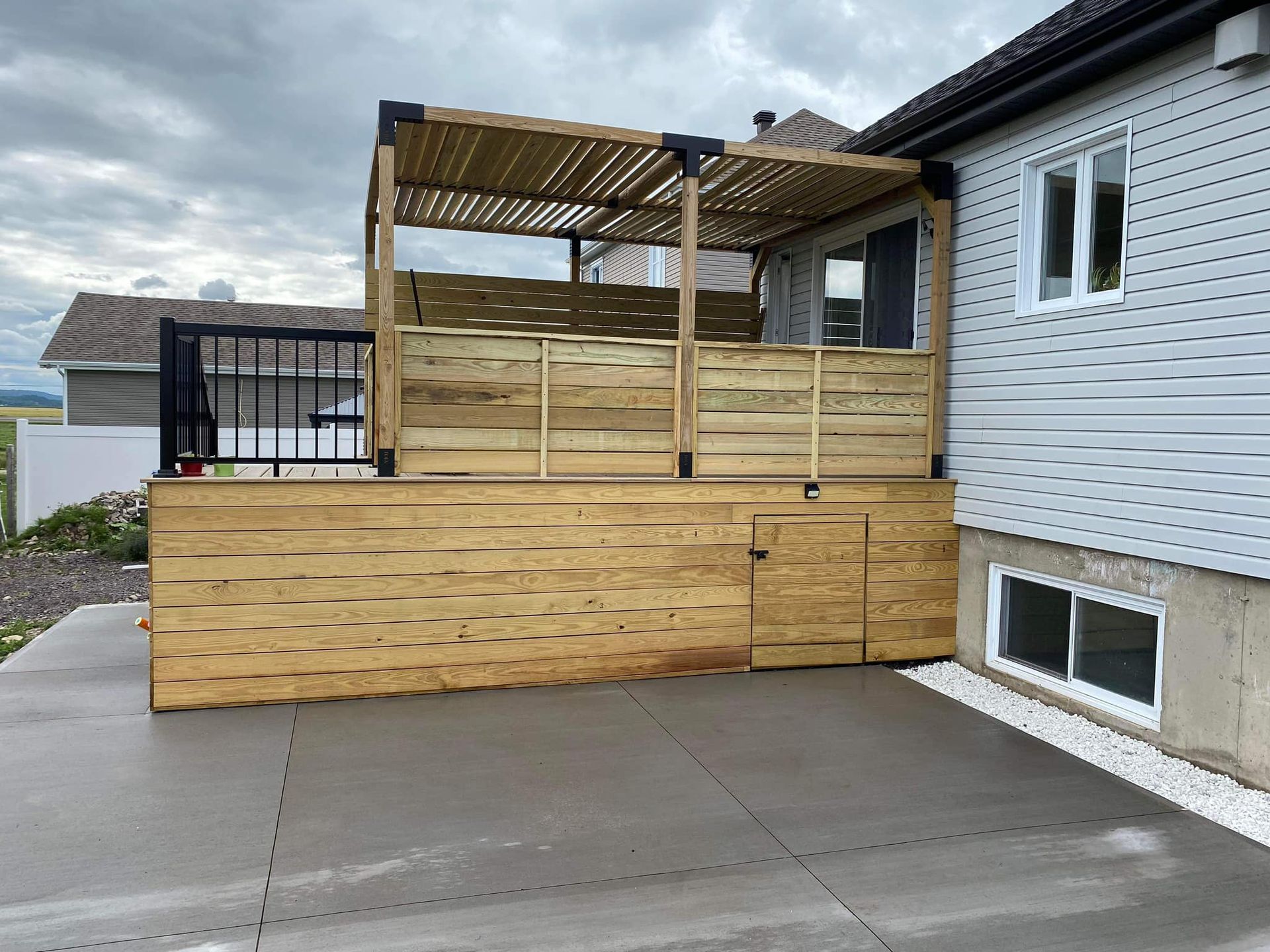 Une terrasse en bois est posée sur le côté d'une maison.