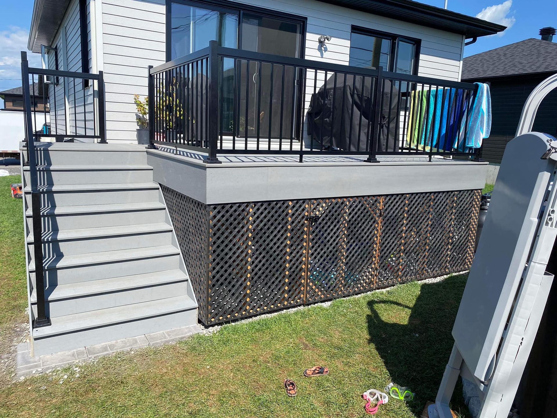 Une maison blanche avec une terrasse et des escaliers devant.