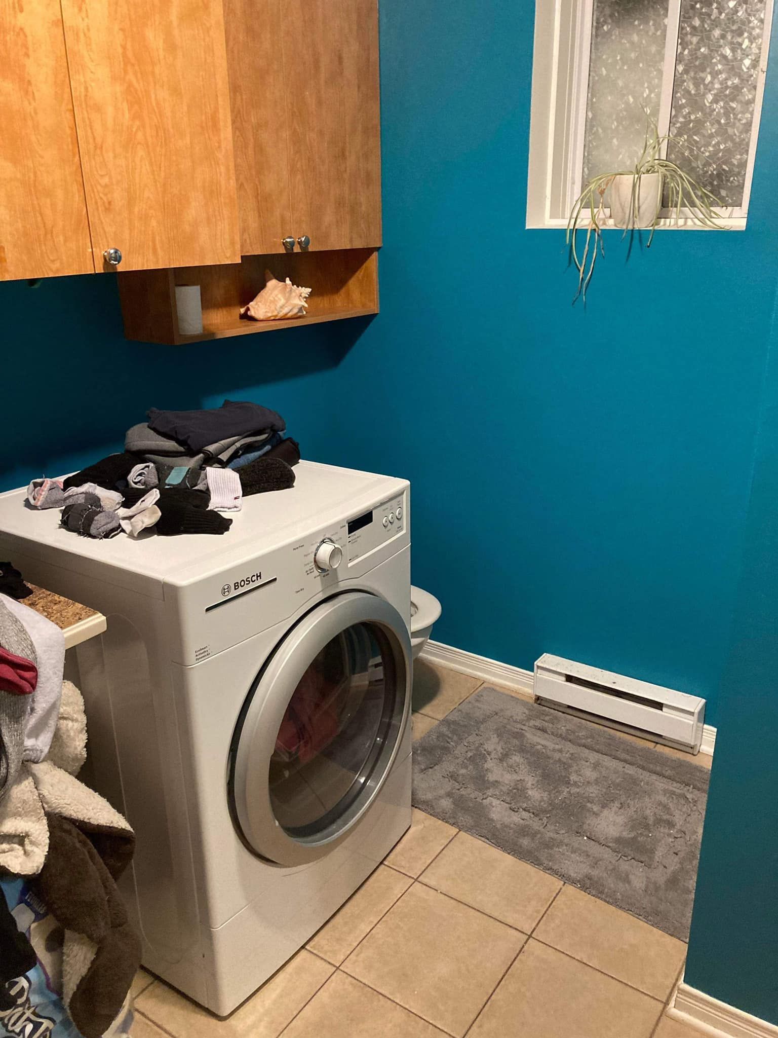 Une buanderie avec machine à laver et sèche linge.