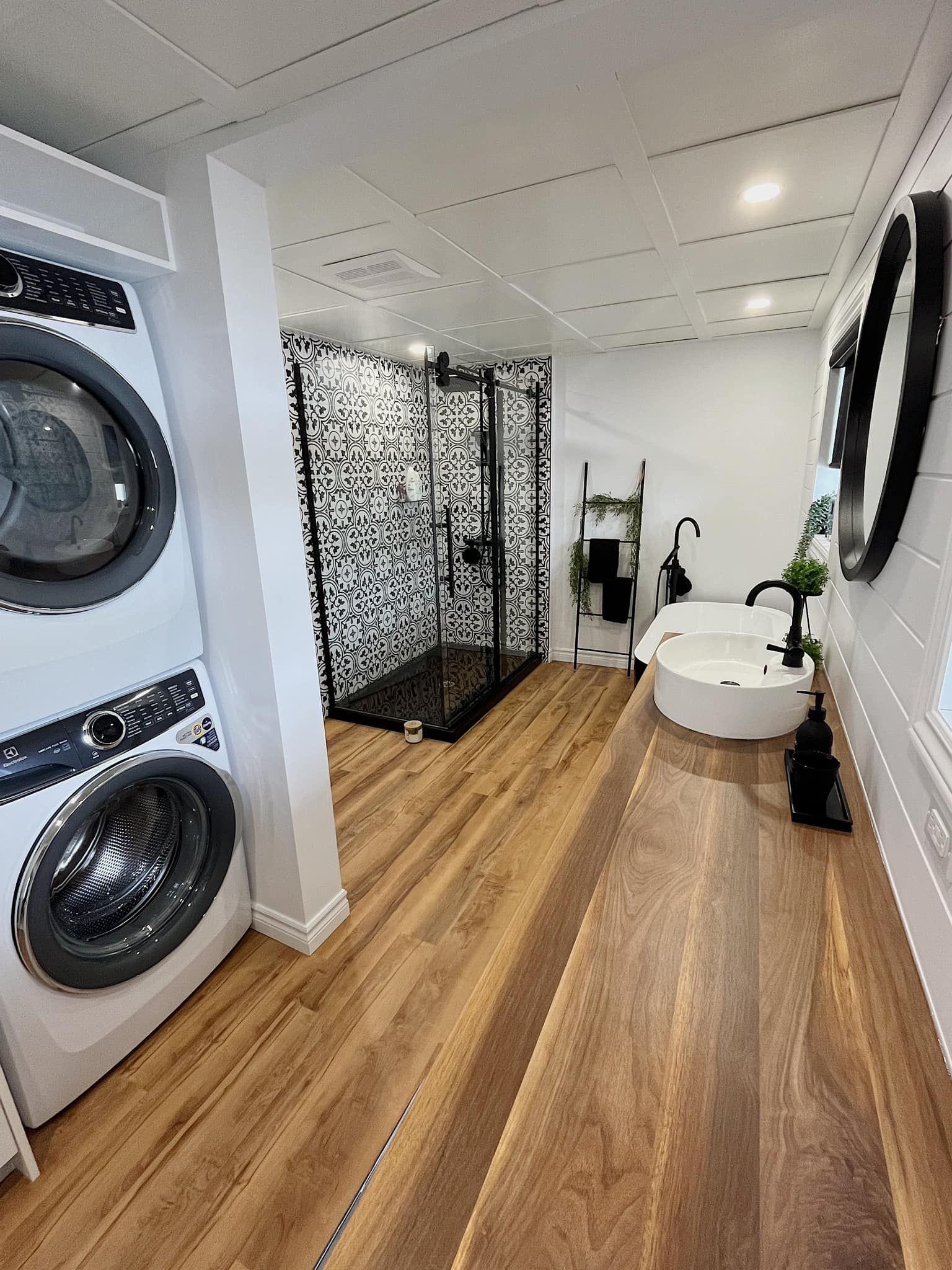 Une salle de bain avec laveuse et sécheuse et un lavabo.