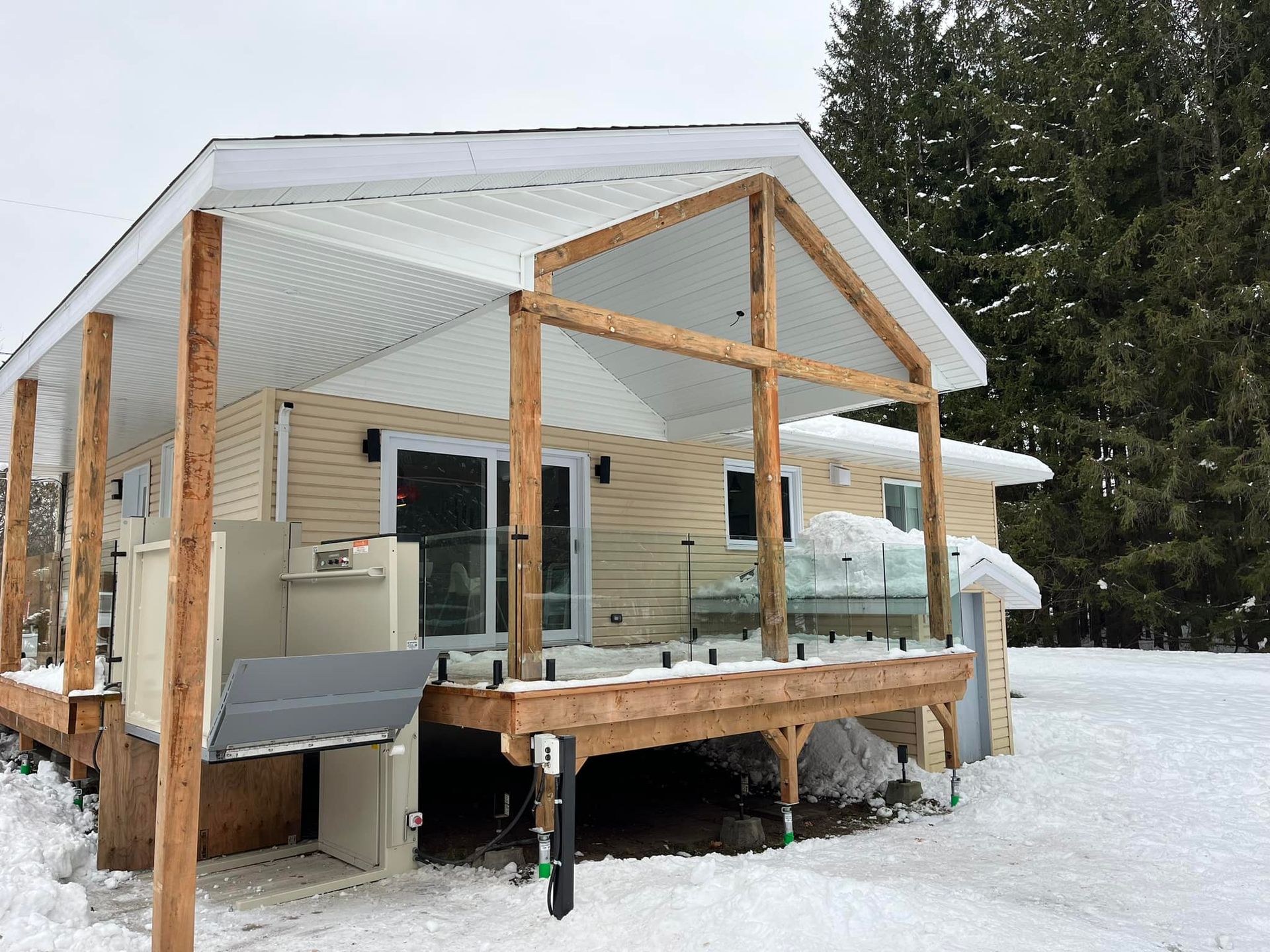 Une petite maison avec un grand porche dans la neige.