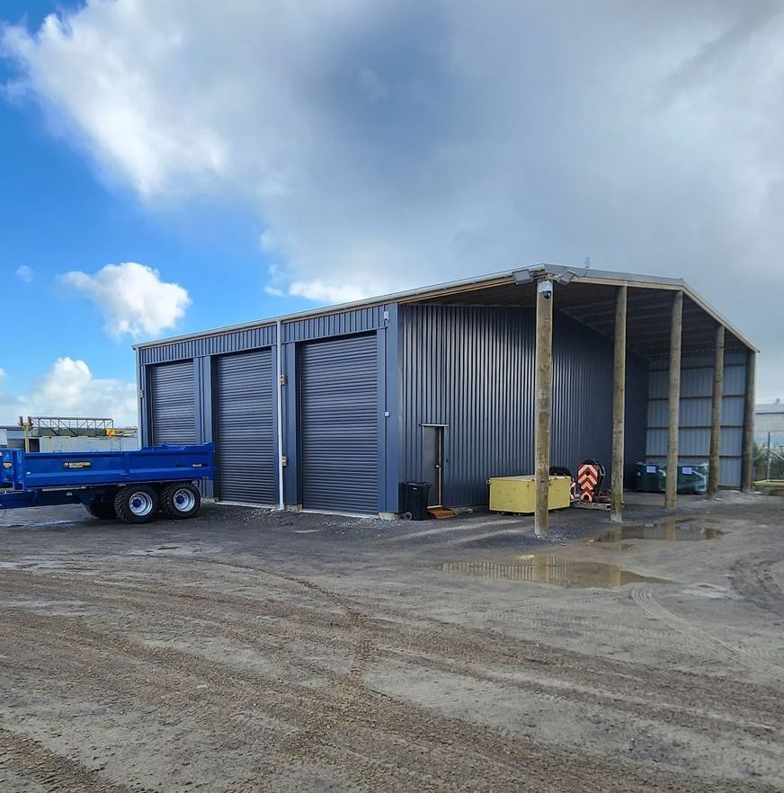 A blue truck is parked in front of a building