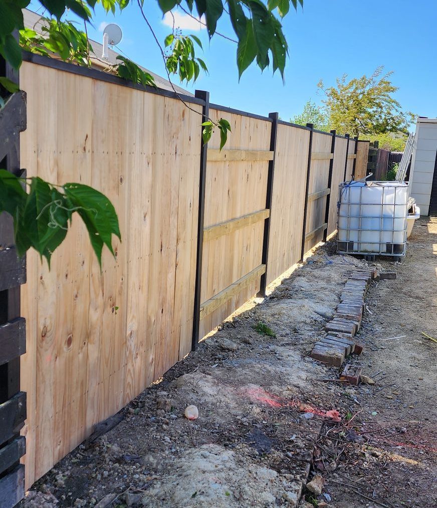 A wooden fence with a container in the background