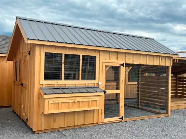 A wooden chicken coop with a metal roof