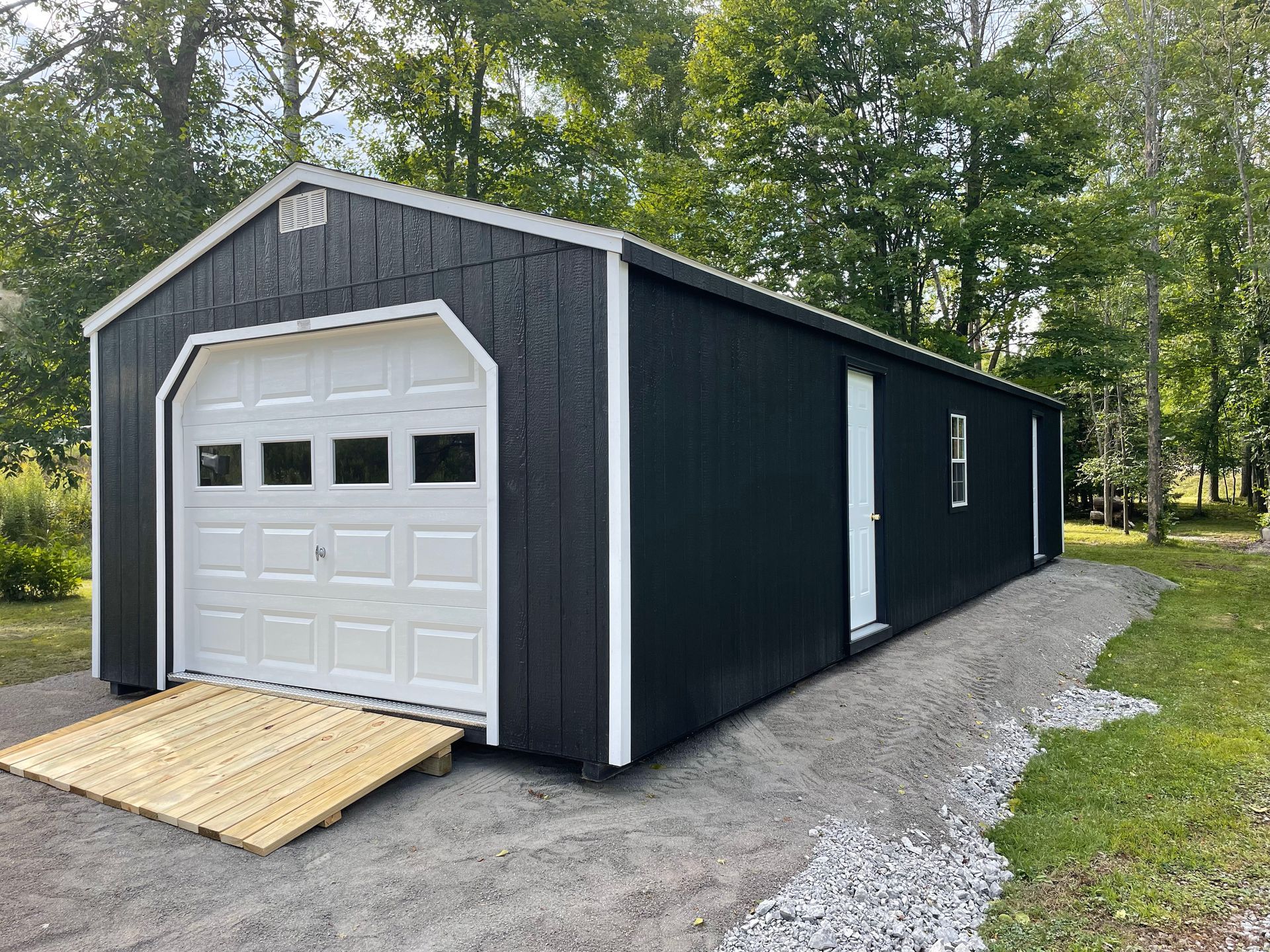 A black garage with a white door and ramp.