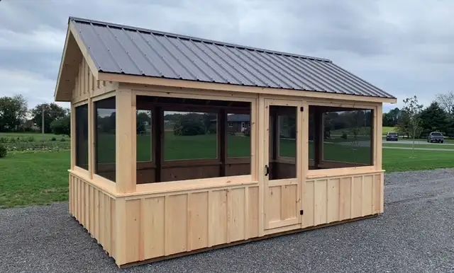 A wooden gazebo with a screened in porch and a metal roof.