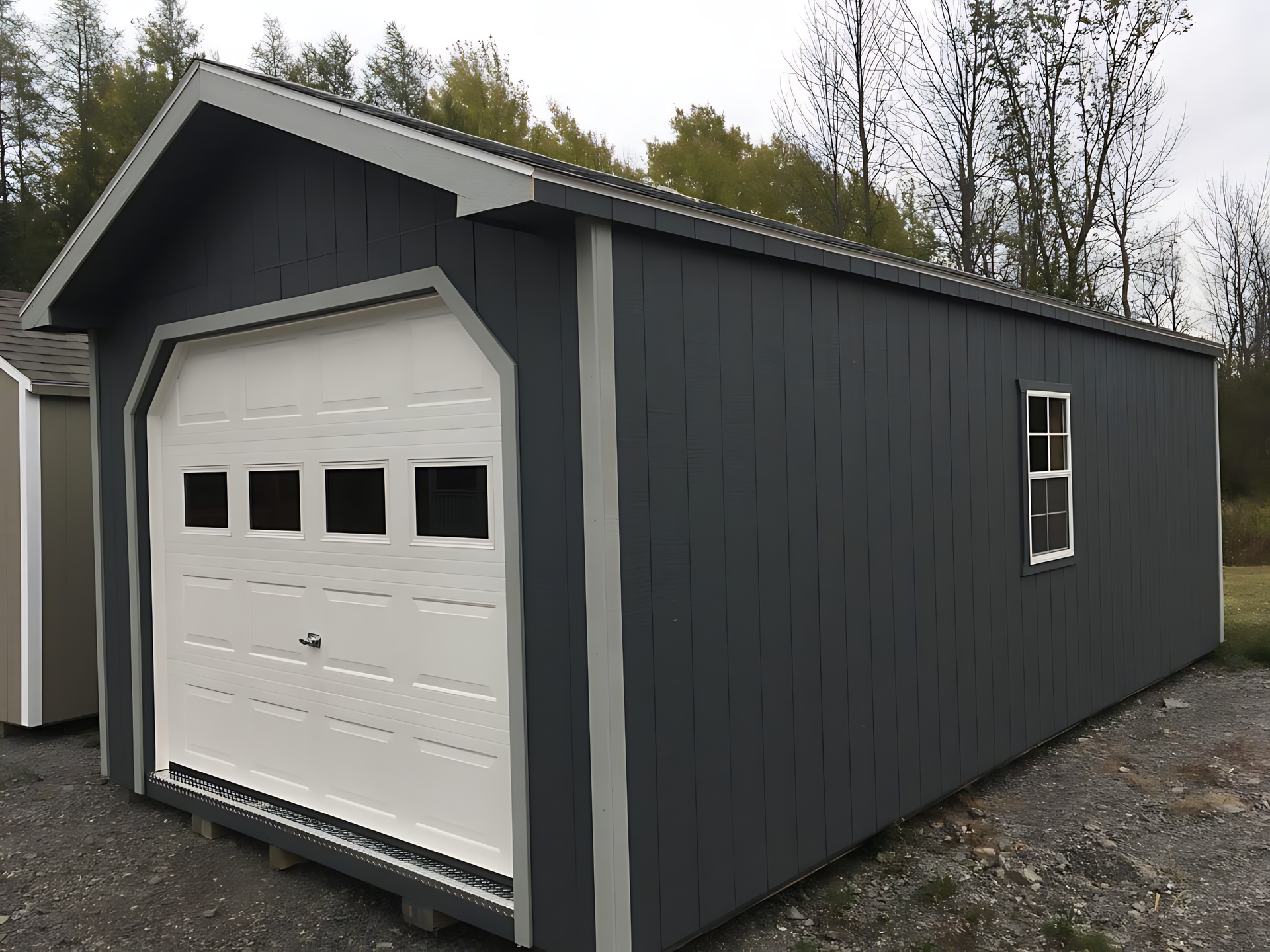 A gray garage with a white garage door and a window.