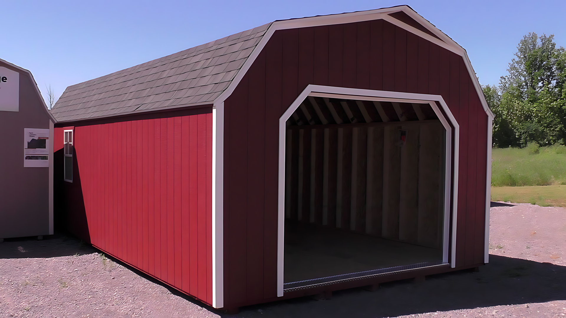 A red barn with the door open and a gray roof