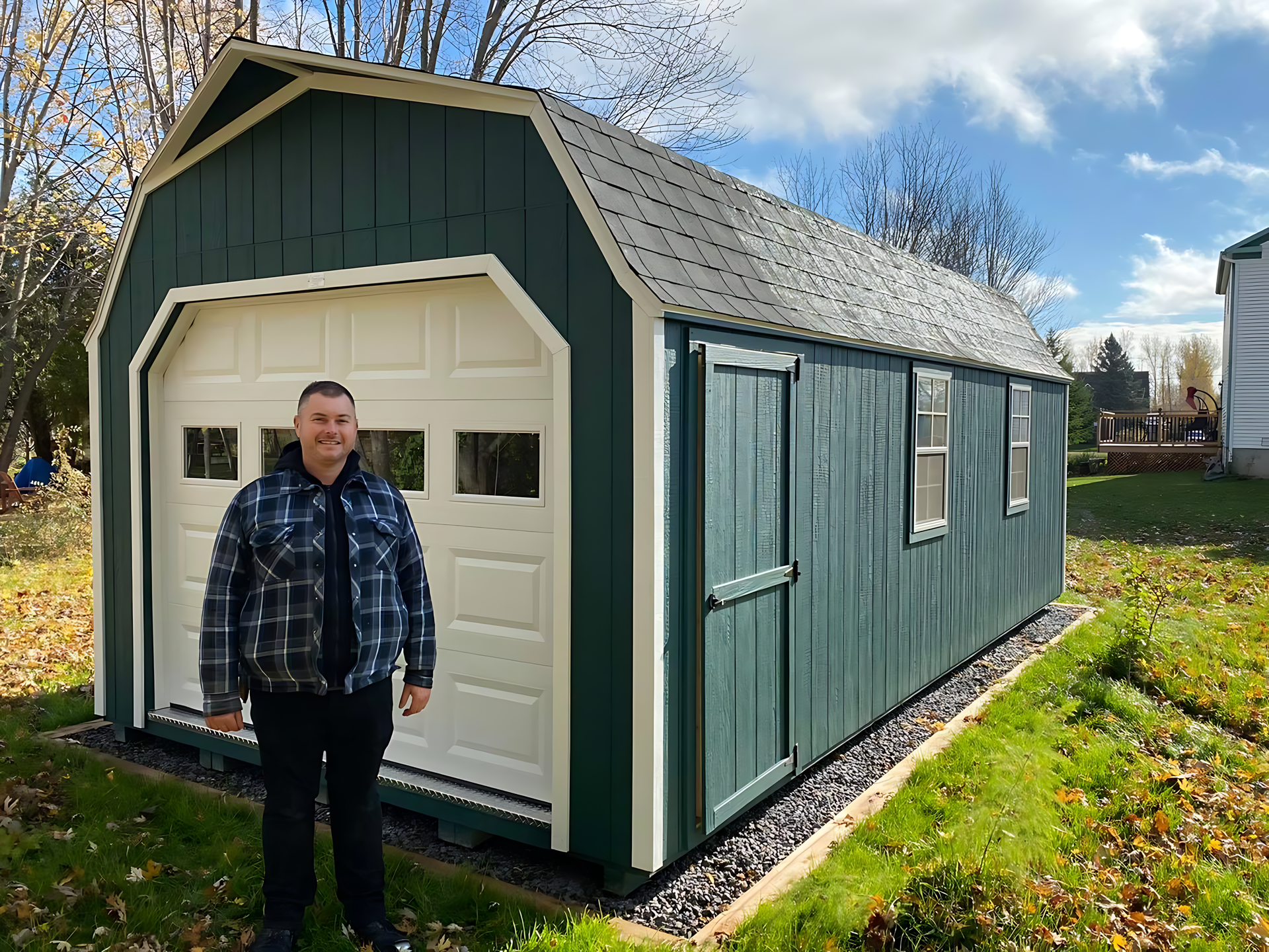 A man is standing in front of a green garage.